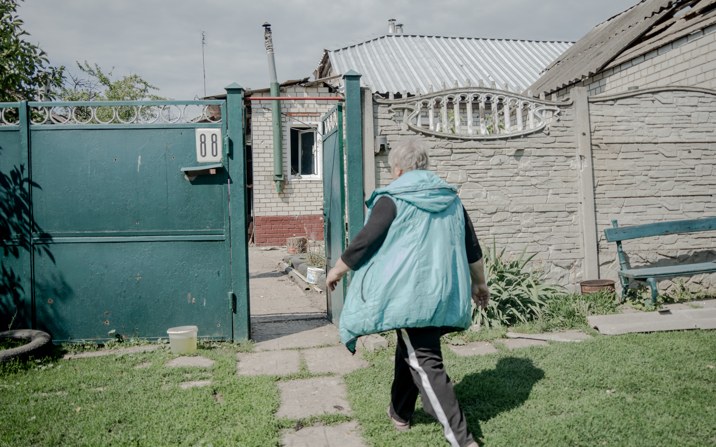 Valentina, 69, walks towards her home in Cherkaska Lozova. Russian double-tap attack killed her husband Mykola on May 19, 2024 / Photo: Ivan Samoilov for Gwara Media