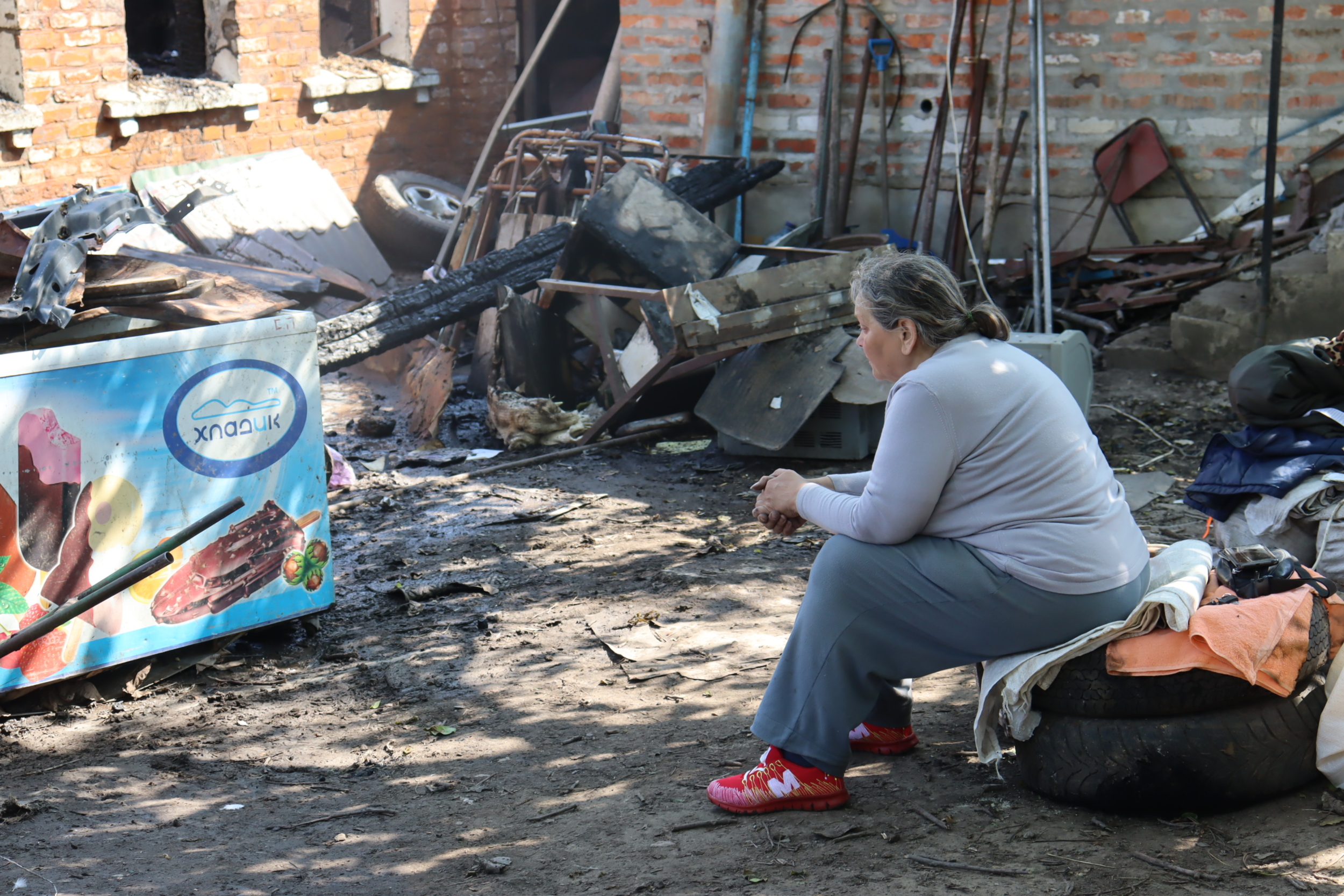 Olena watching her destroyed house in Kulynychi, a village Russia attacked with a drone strike on May 21, 2024 / Photo: Yana Sliemzina for Gwara Media