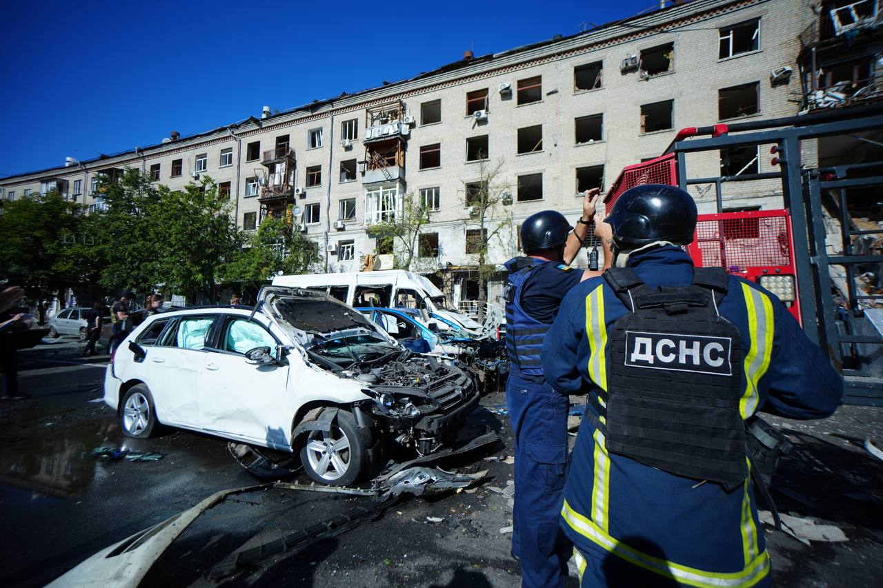 Emergency service workers in front of a building damaged by a Russian glide bomb attack on the center of Kharkiv on June 22, 2024