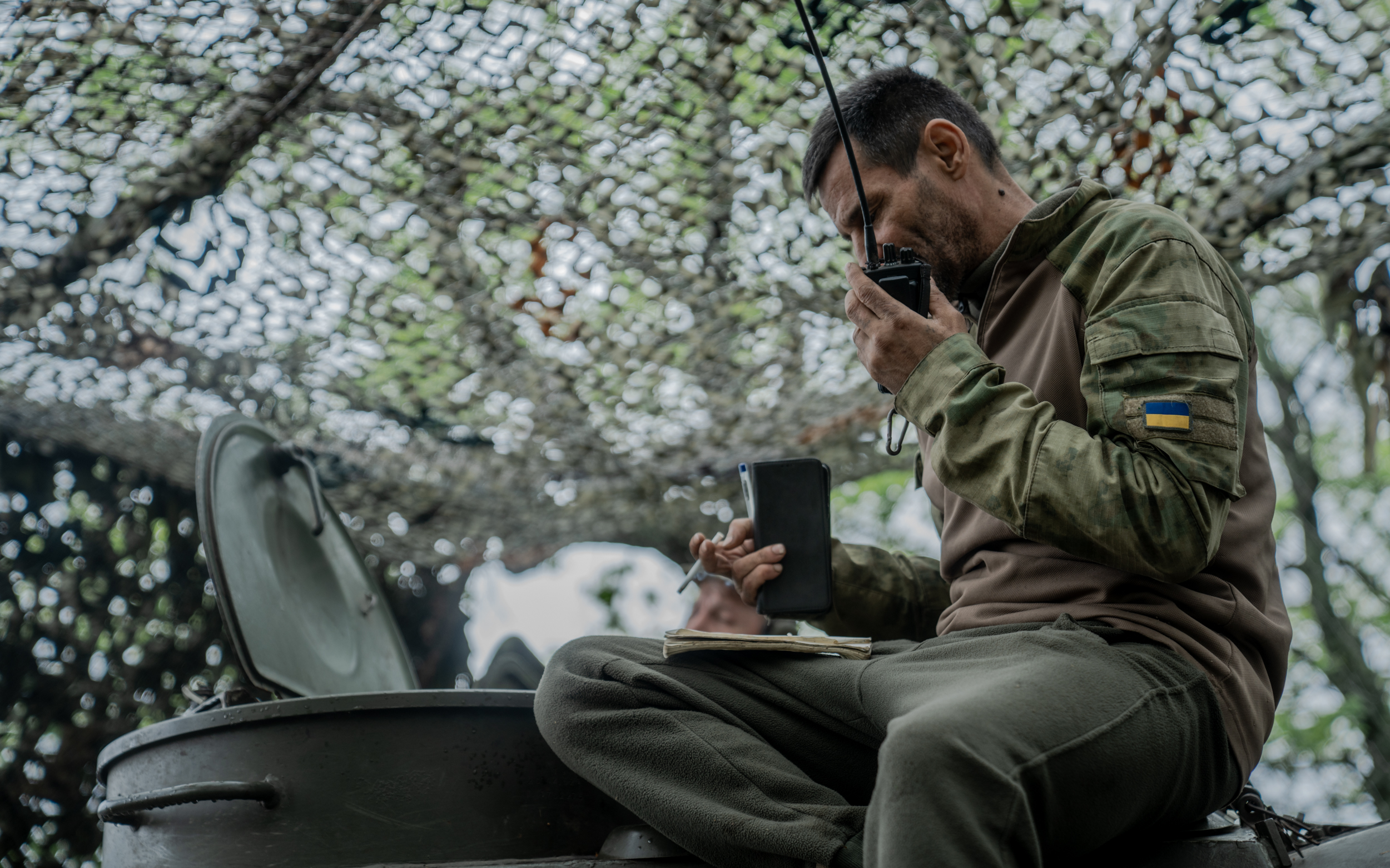 Soldier of 57th brigade talks into the walkie-talkie on Kupiansk direction, Kharkiv Oblast / Photo: Ivan Samoilov for Gwara Media