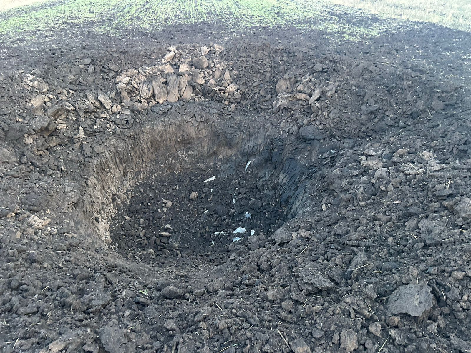 An impact crater of a Russian glide bomb dropped on one of the villages in Zolochiv community on Jan 1, 2024 / Photo: provided by Viktor Kovalenko