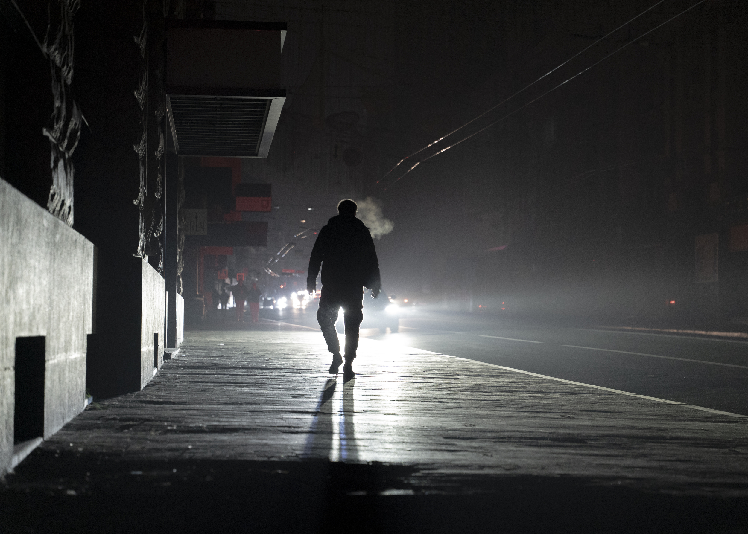 A man walks down a dark street during a blackout after another Russian attack on Kharkiv