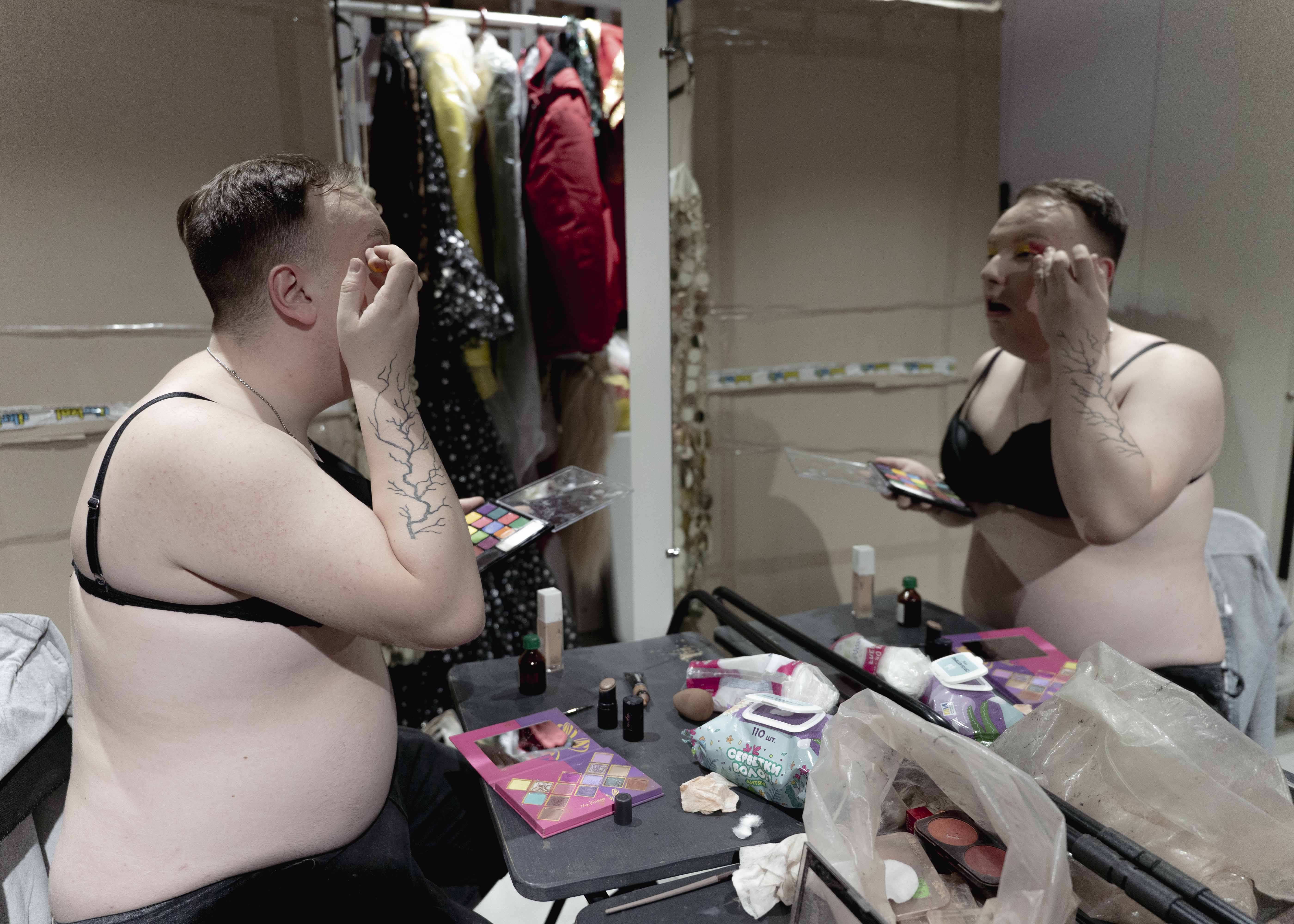 Cassima paints her eyelids in front of the mirror