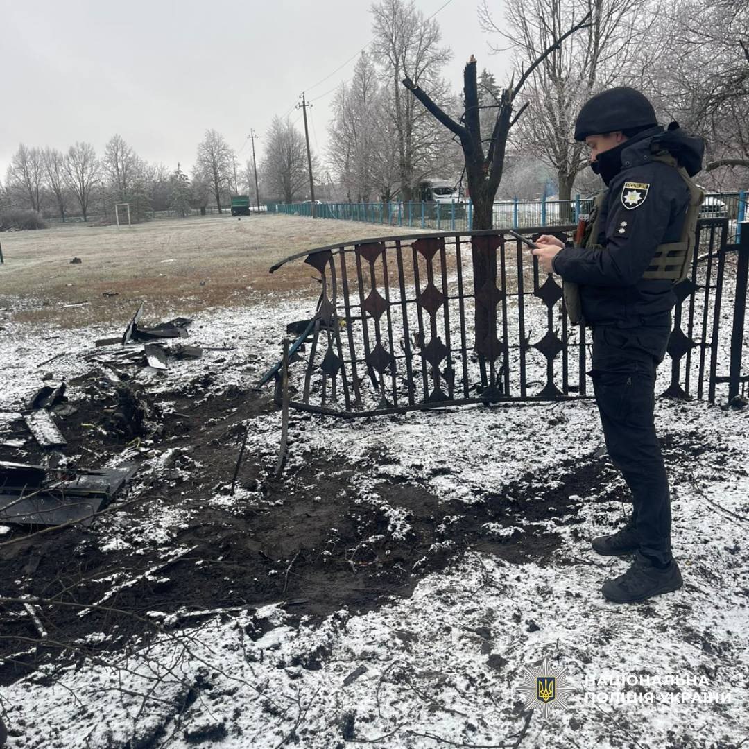 A police officer documents the consequences of a Russian attack on a settlement in the Kharkiv region
