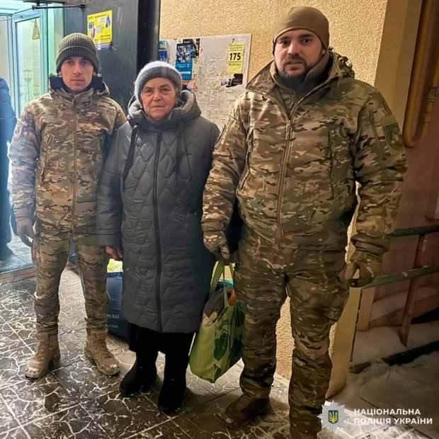 Two man in the military unitform are flanking a woman in the winter clothes