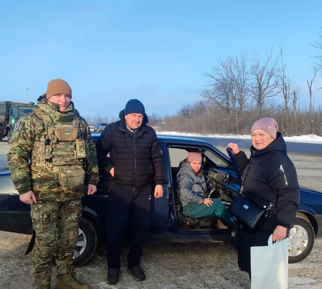 People standing in front of the car during winter