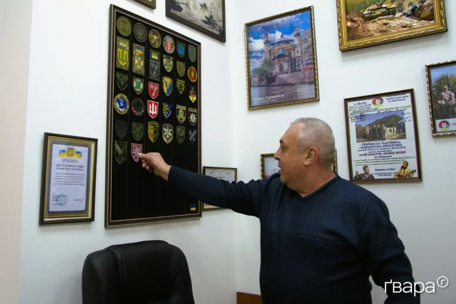 Олег вішає подарований Сергієм шеврон на стіну