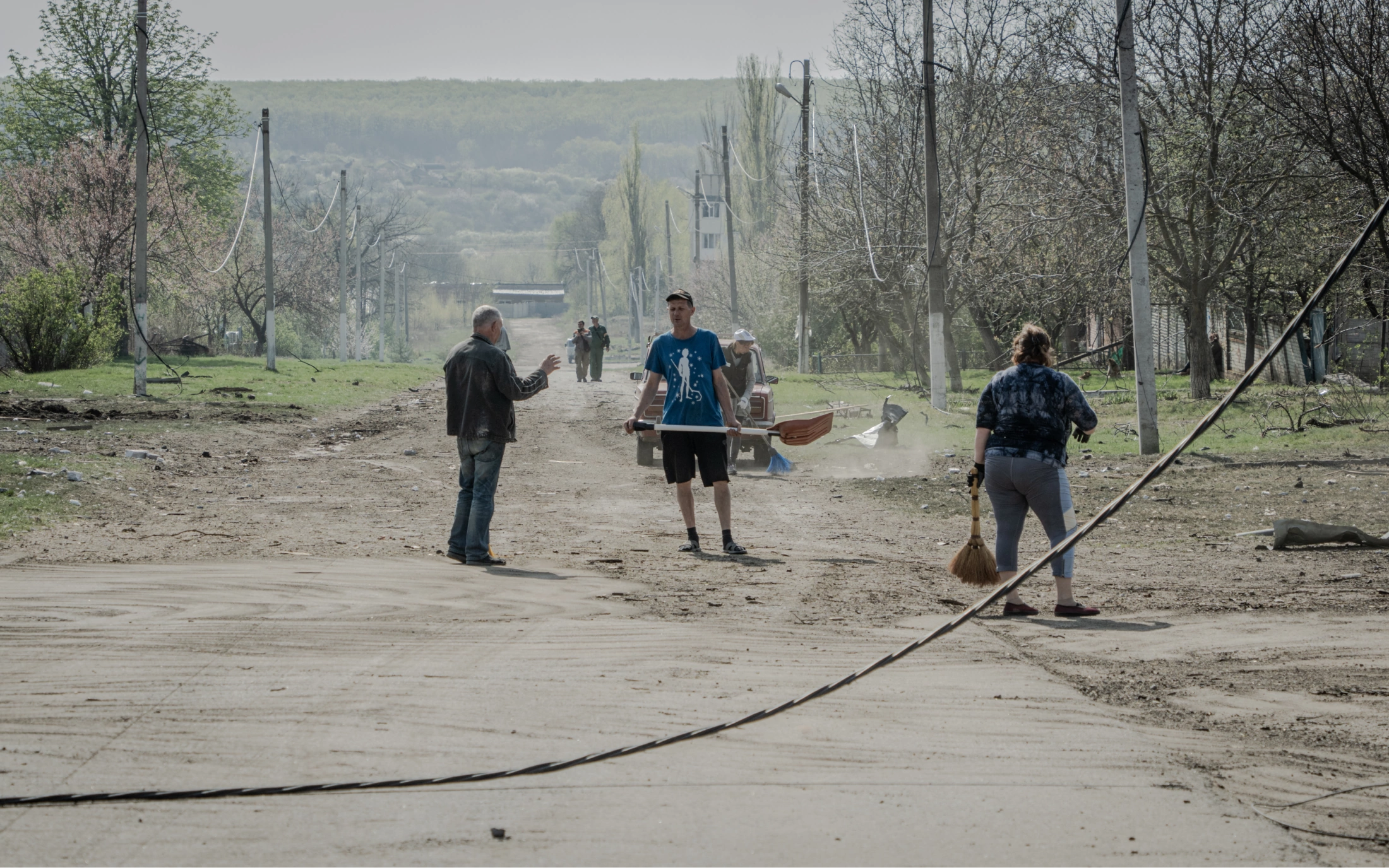 Residents of Velyki Prokhody, Kharkiv region, clean up the village after Russians dropped aerial bomb on it on April 11, 2024 / Photo: Ivan Samoilov for Gwara Media