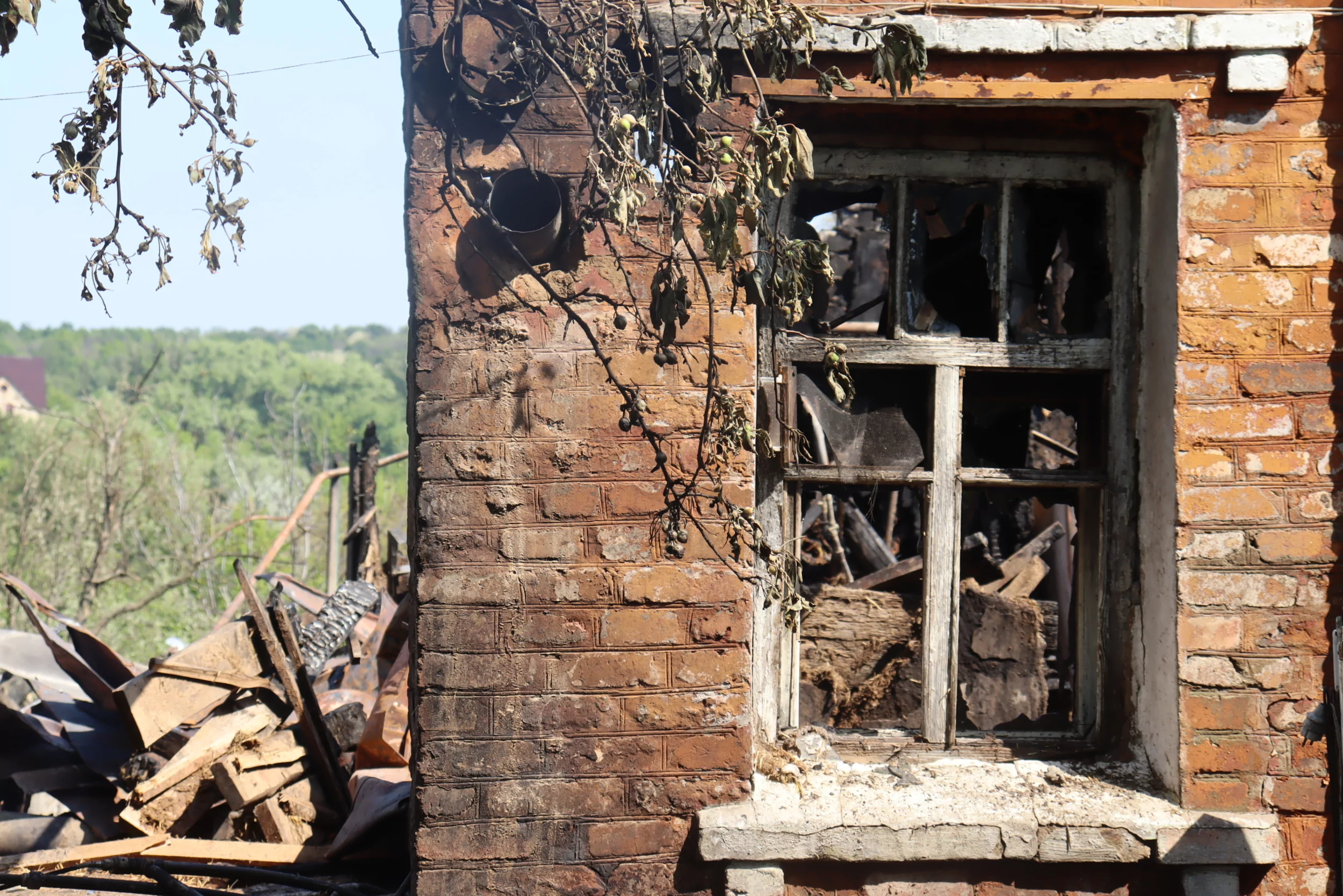 Olena watching her destroyed house in Kulynychi, a village Russia attacked with a drone strike on May 21, 2024 / Photo: Yana Sliemzina for Gwara Media
