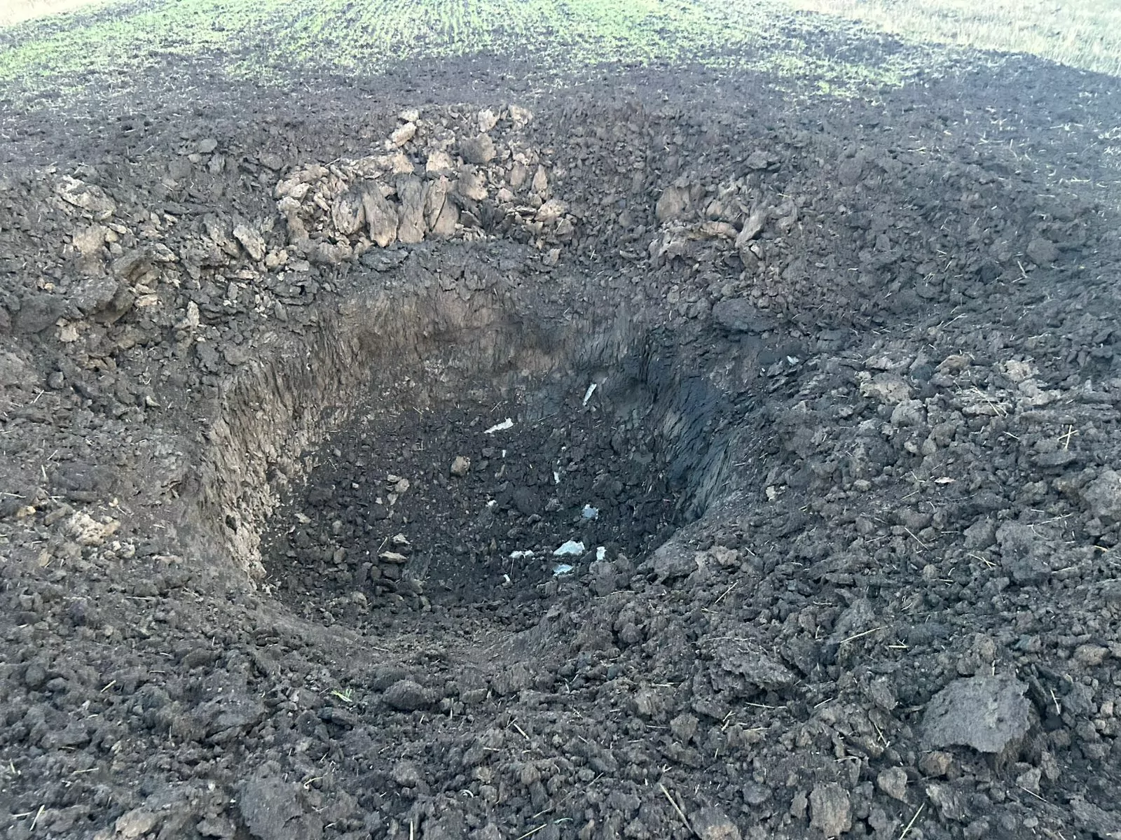 An impact crater of a Russian glide bomb dropped on one of the villages in Zolochiv community on Jan 1, 2024 / Photo: provided by Viktor Kovalenko