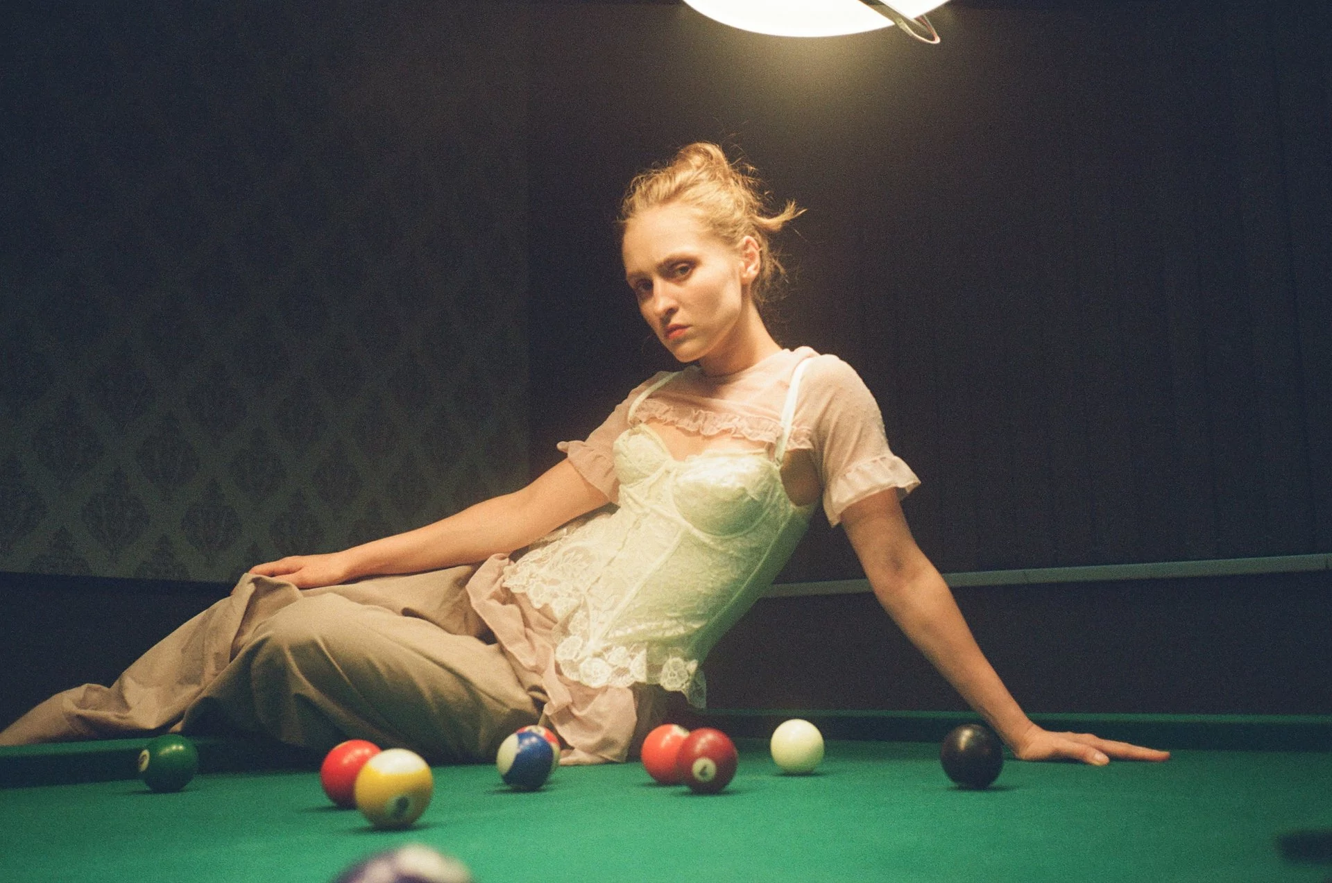 Khartede 20. Nina Khyzhna sits on a billiard table. 2023.