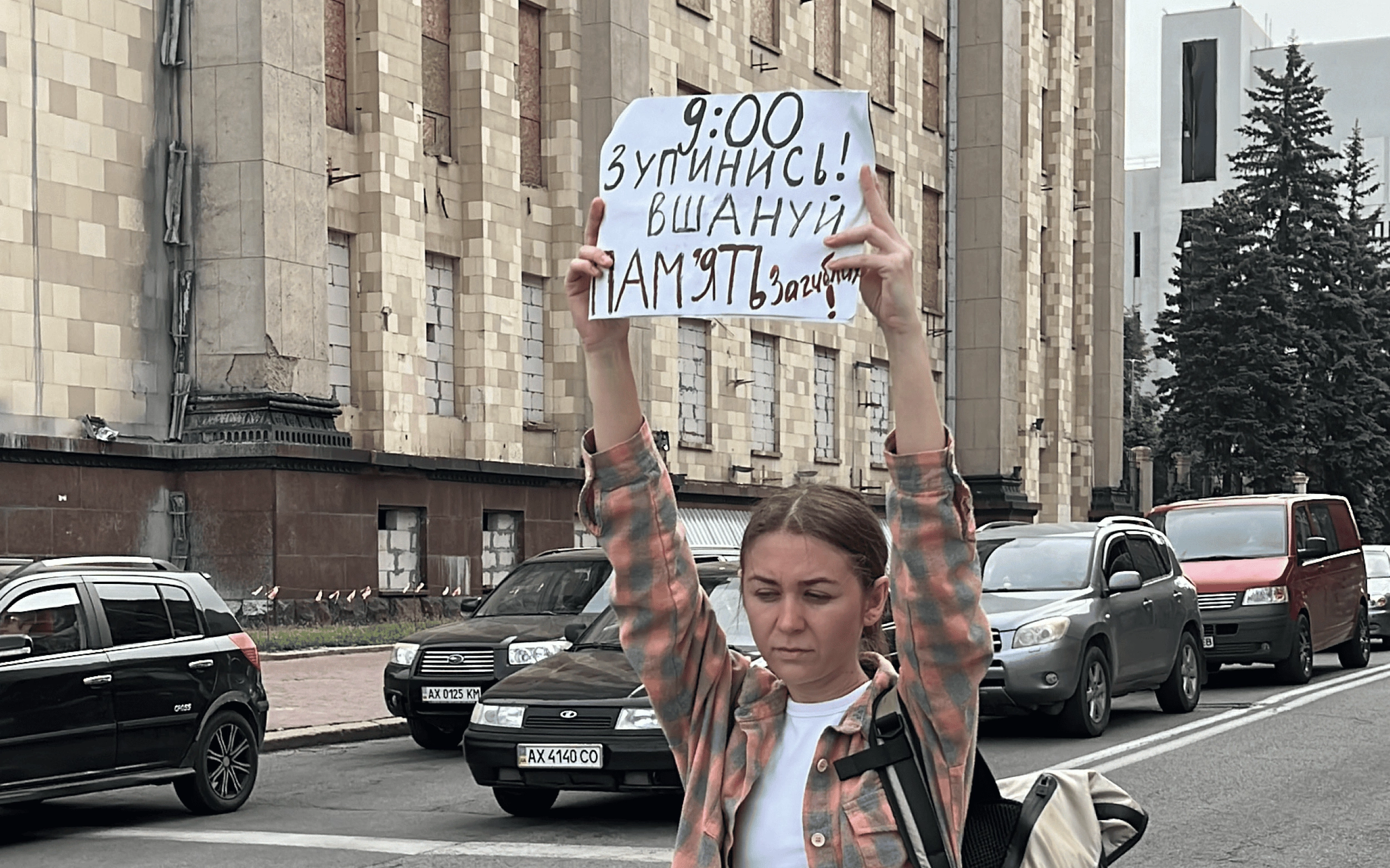 Participant of moment of silence in Kharkiv on May 29 with banner: 