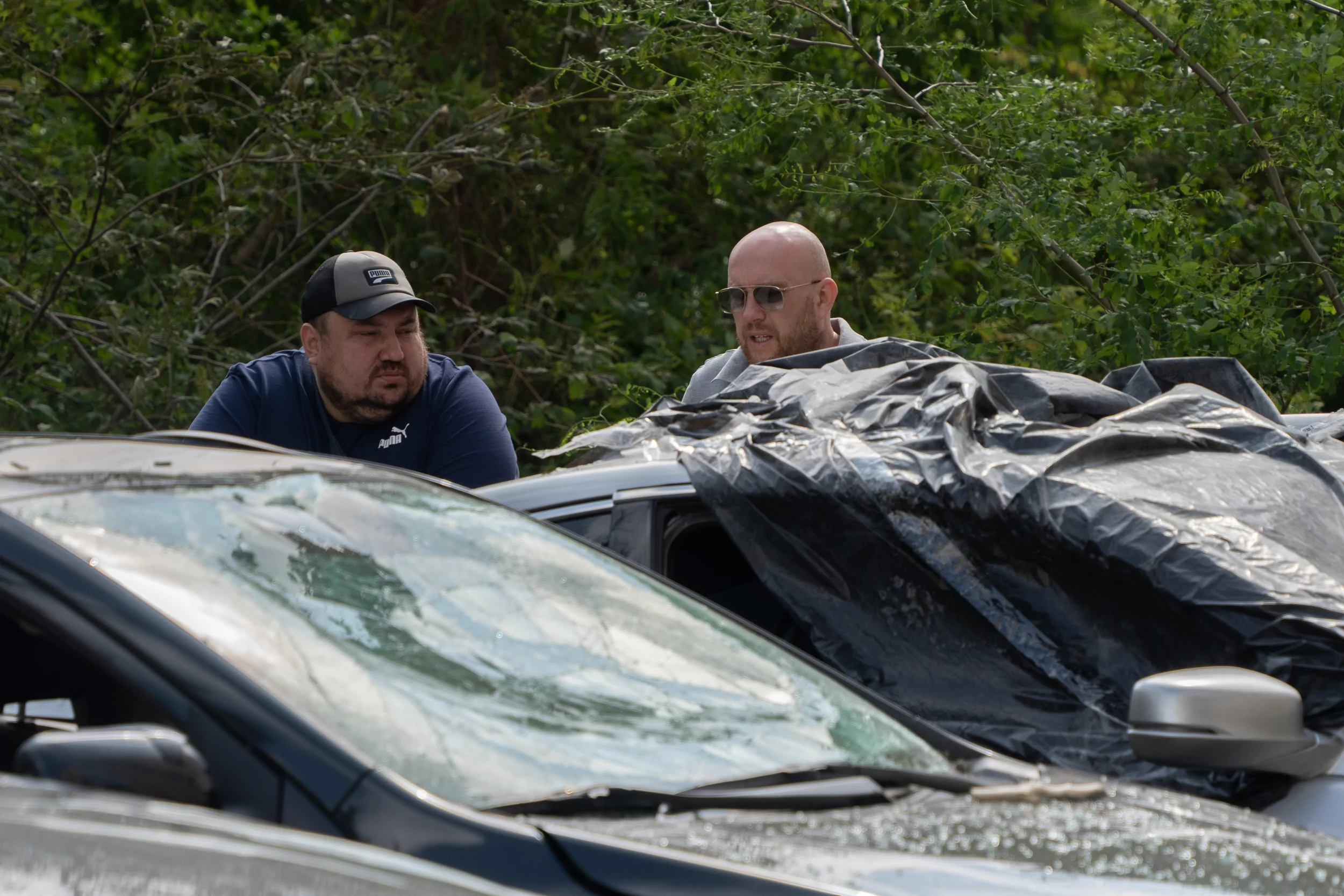 Locals with their damaged cars in Shevchenkivskyi district after Russian attack on June 20
