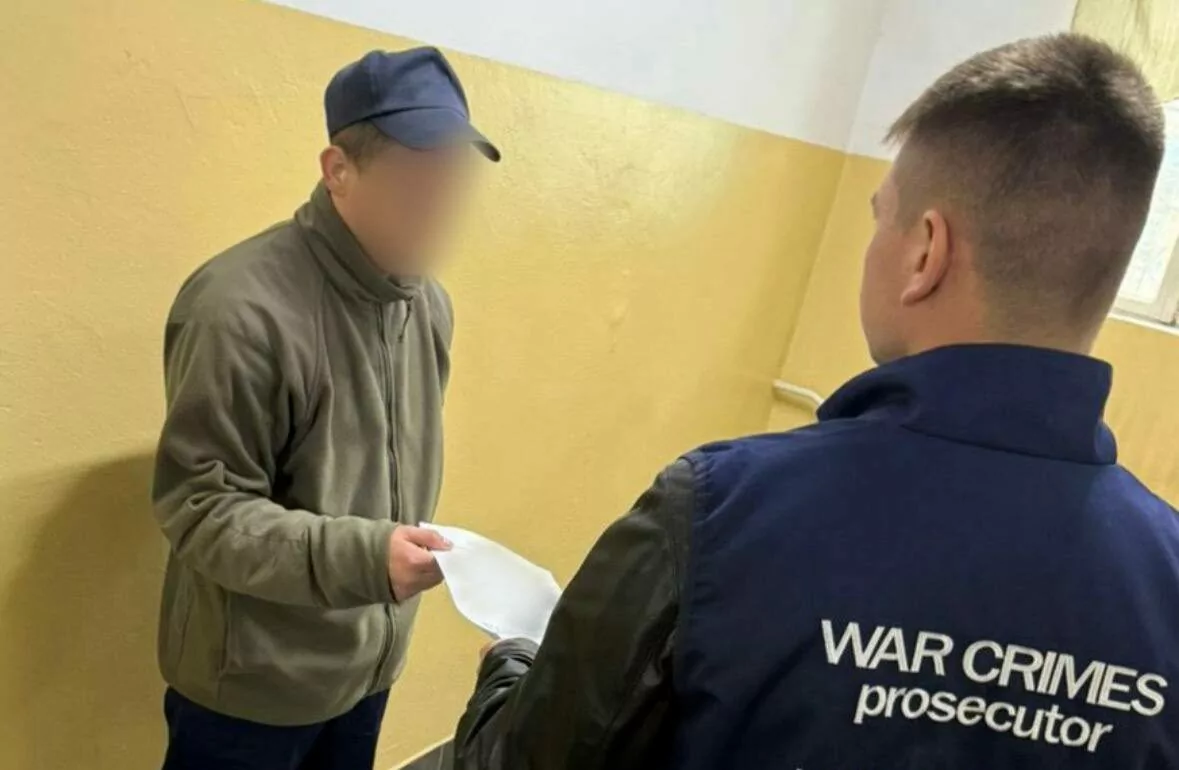 Прокурор вручає повідомлення російському полоненому