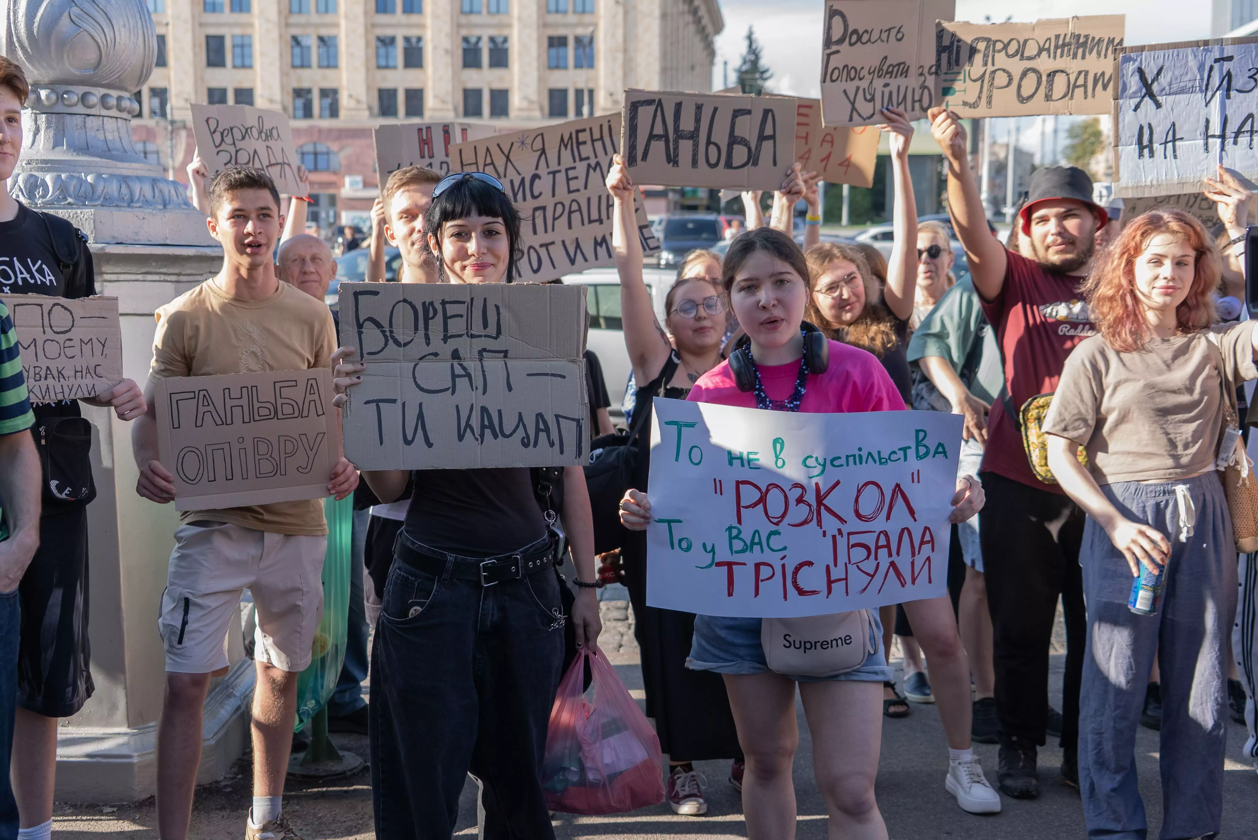 Two protesters in the center hold the posters with the signs 