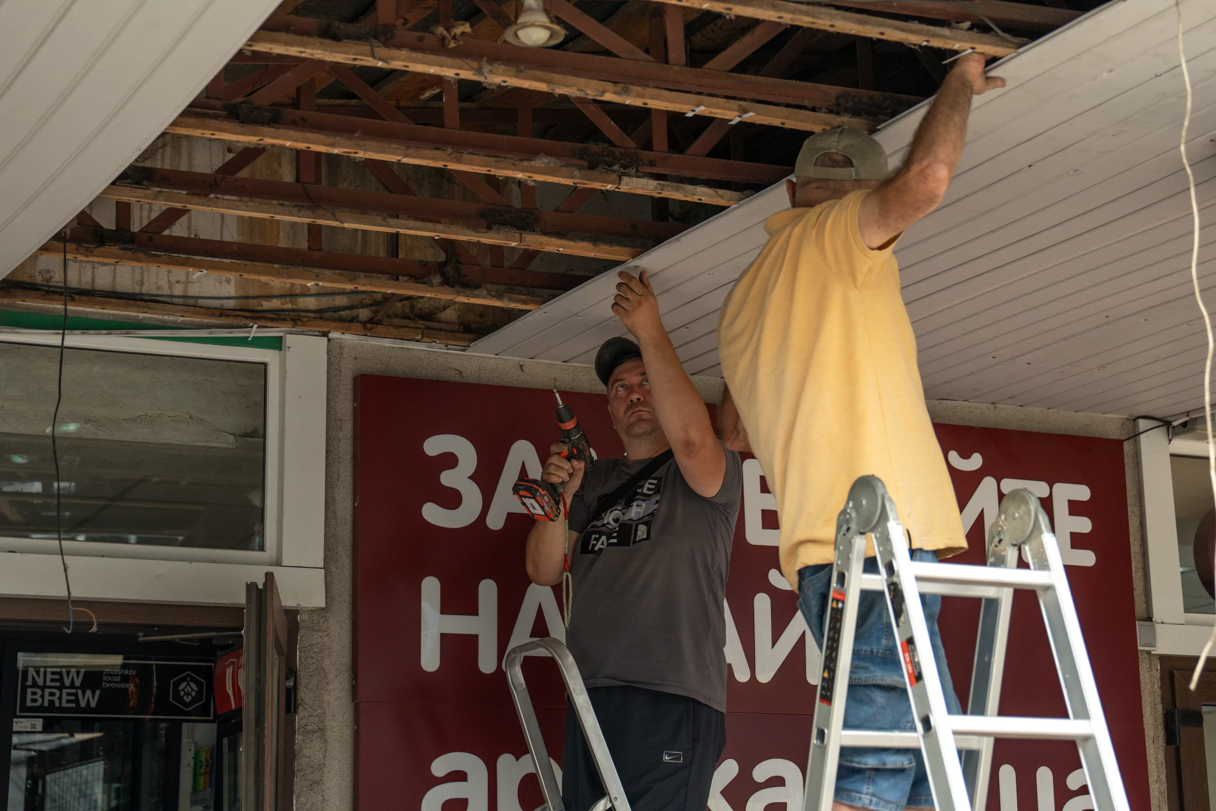 People repairing the ceiling damaged after the overnight Russian drone attack on Kharkiv on Jul 30, 2025