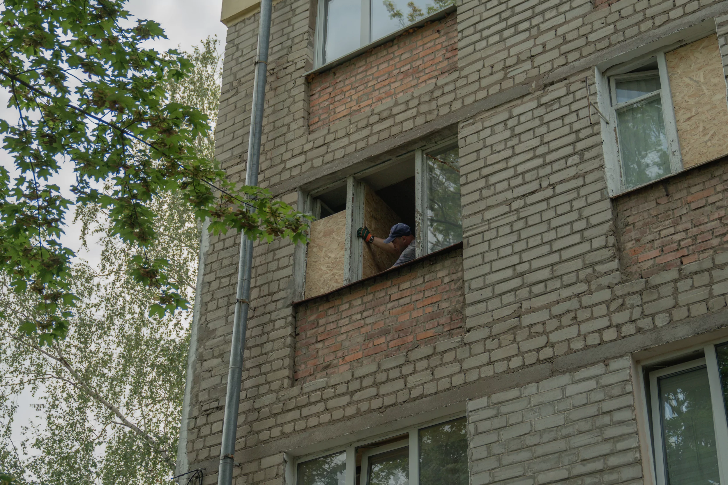 People boarding up the window blasted out after the overnight Russian drone attack on Kharkiv on Jul 30, 2025