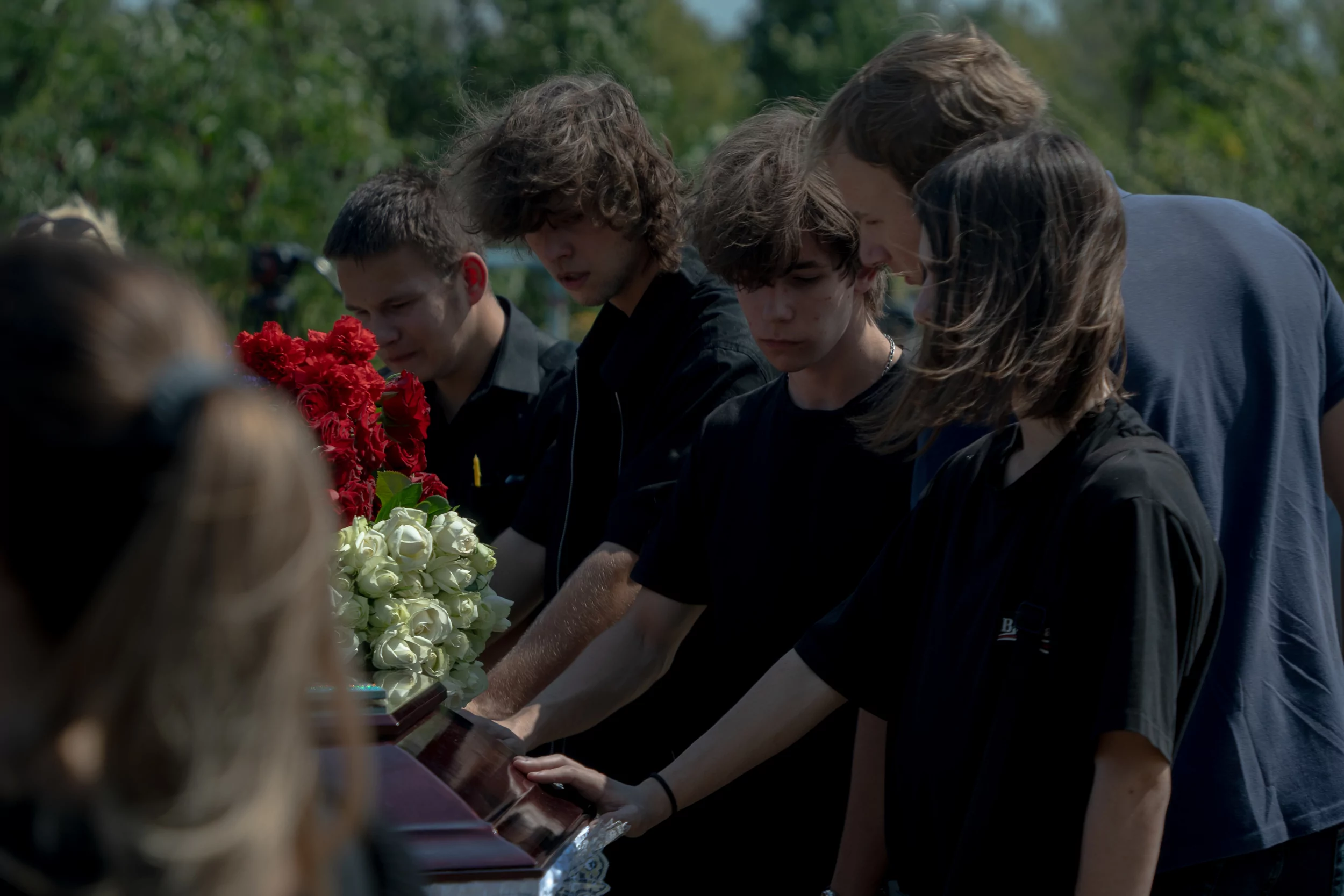 Friends of 16-year-old Artem stand near his coffin