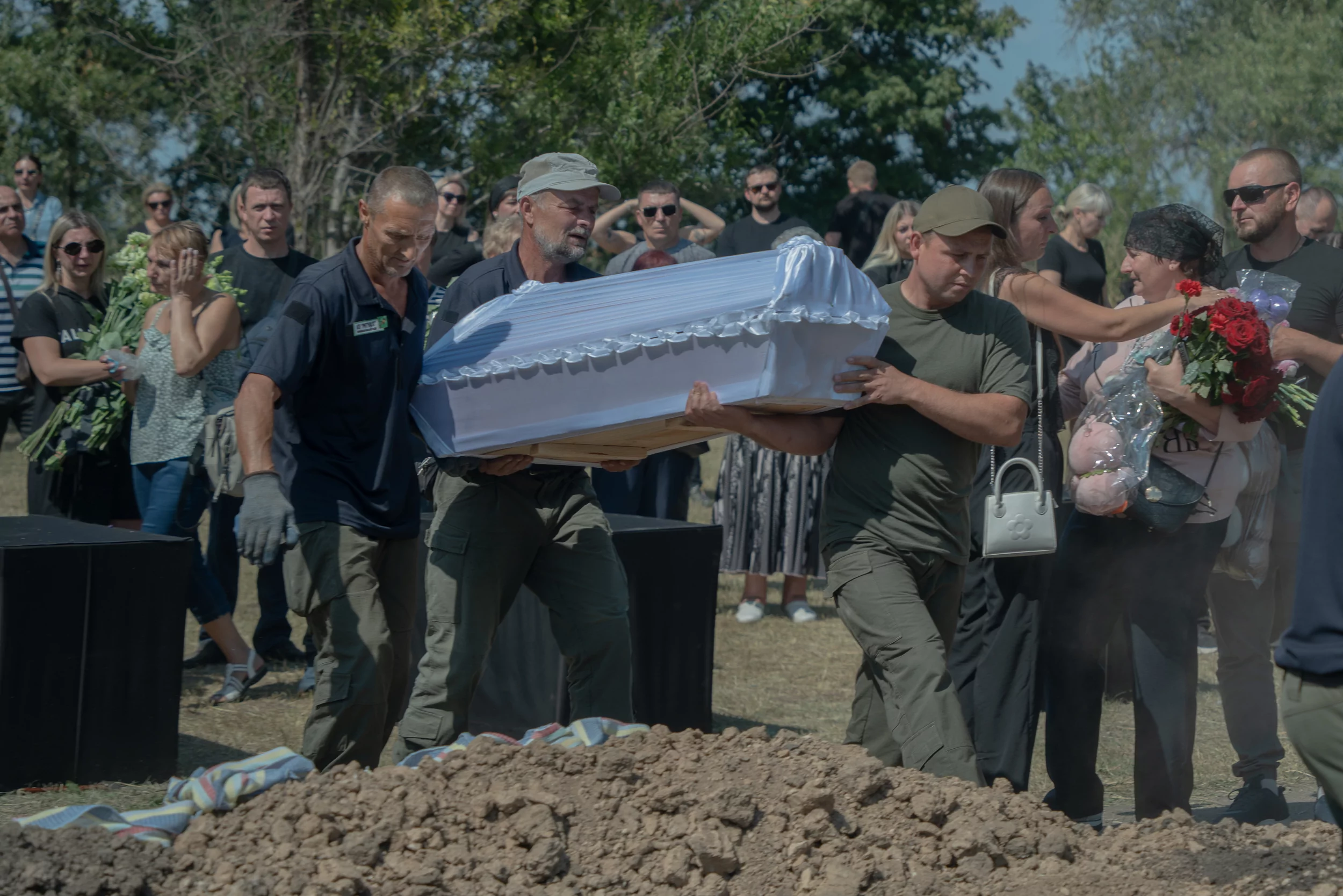 Cemetery workers carry coffin of Miia, a 1.5-year-old girl from killed family