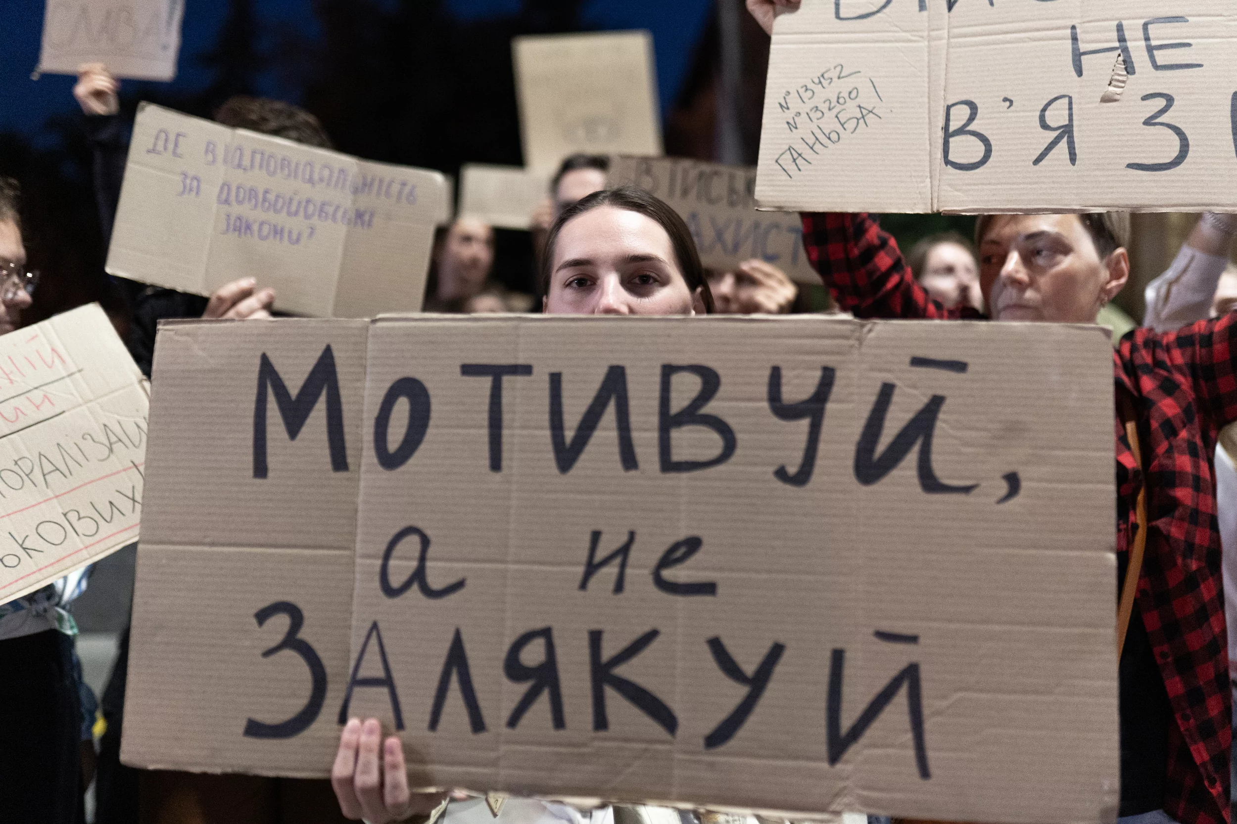 A protester holding a sign reading “Motivate, don't intimidate” at a protest in Kharkiv on September 7