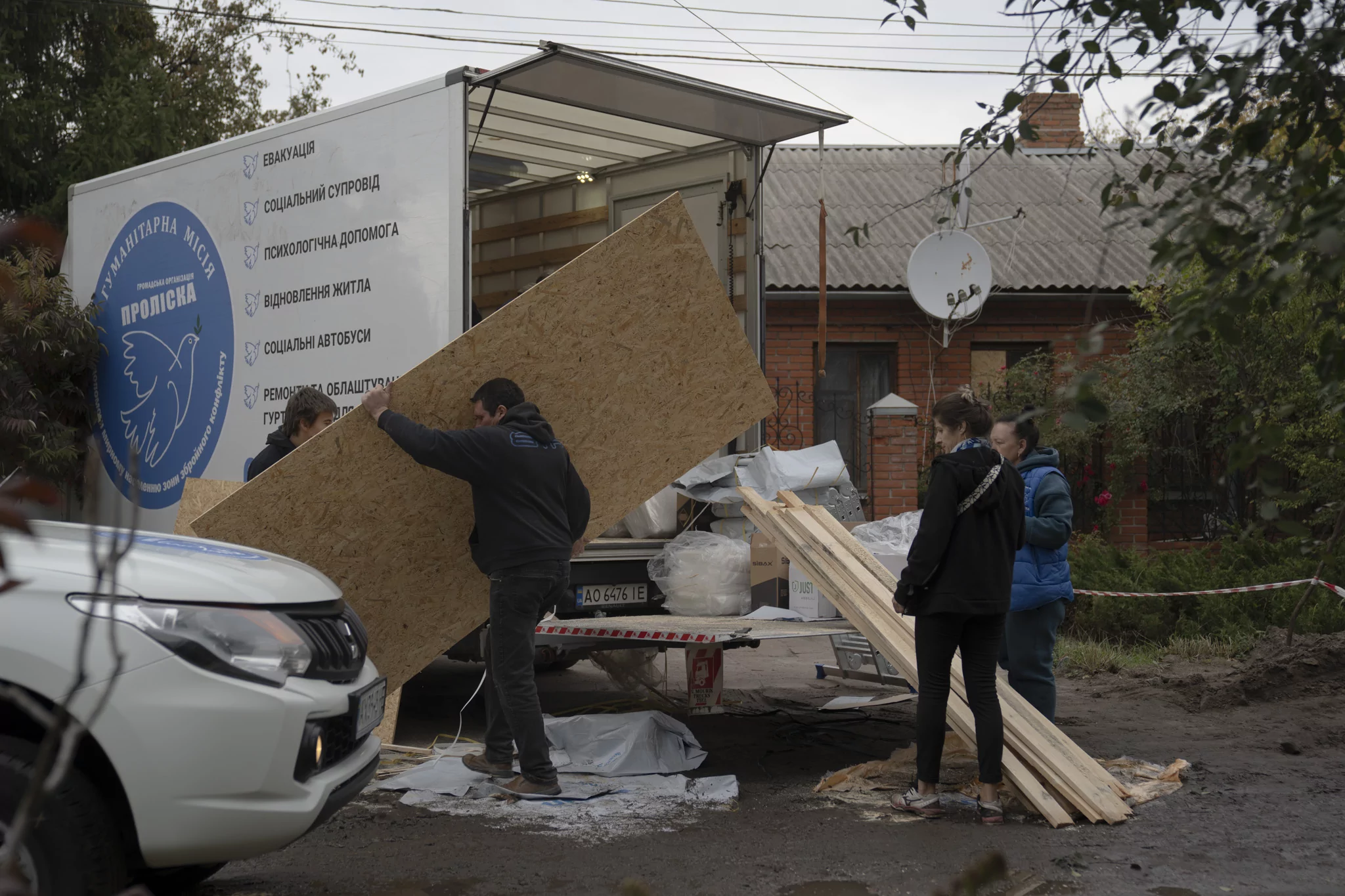 People covering broken windows after Russian attack on Novobavarskyi district of Kharkiv on Oct. 5