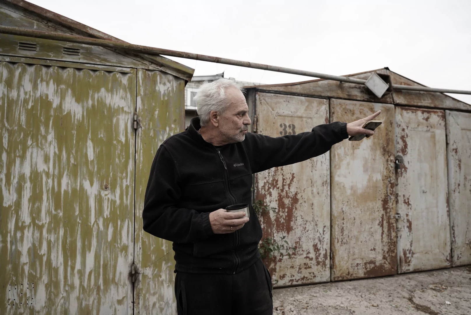 Yevhenii points to the damaged car in the Saltivskyi district after Russian attack on Kharkiv on Oct. 1