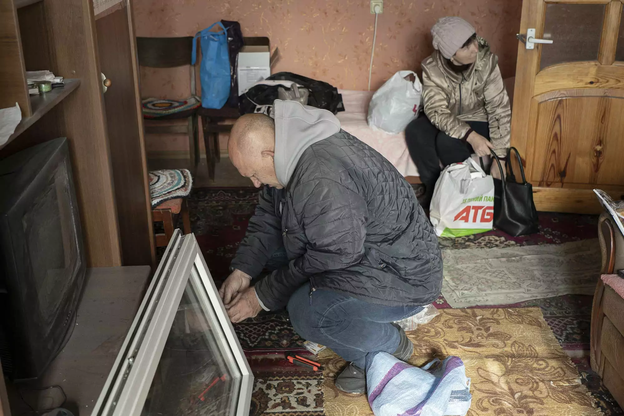 After the Russian attack, Maria's relatives are repairing the window on the balcony