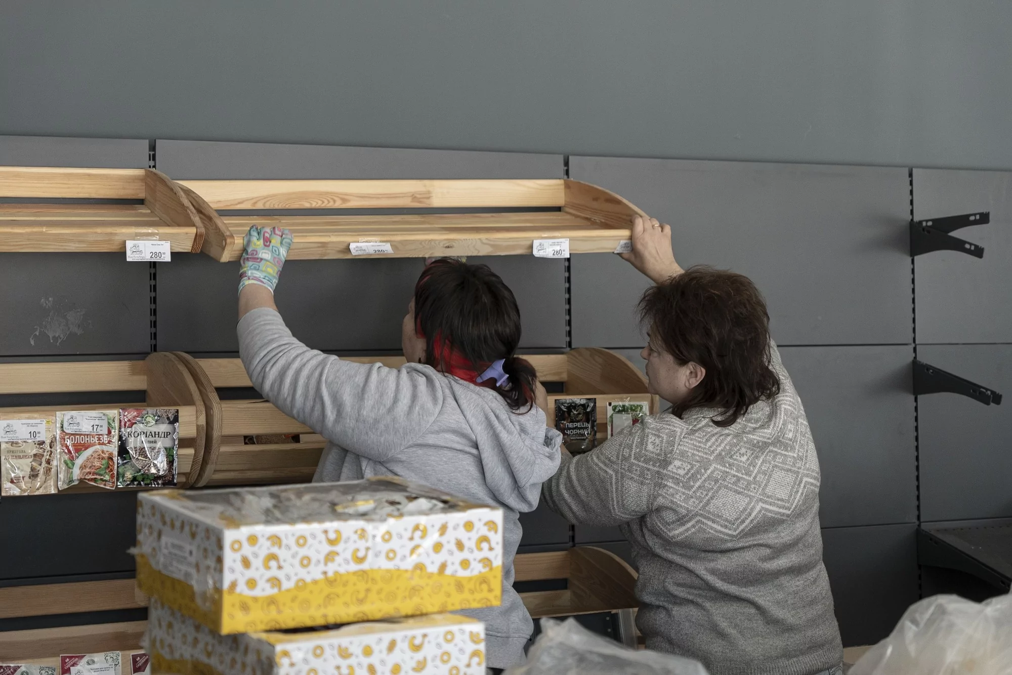 Shop workers put shelves back after the Russian missile strike