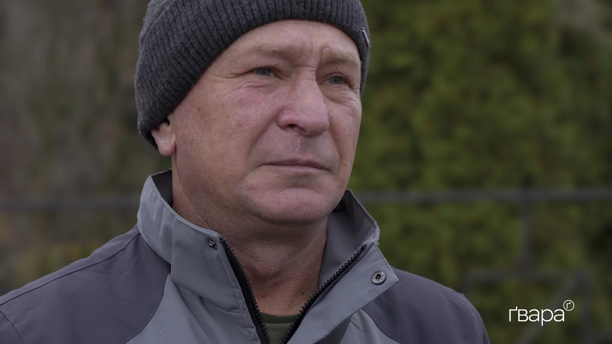 Сумний чоловік у чорній шапці і куртці