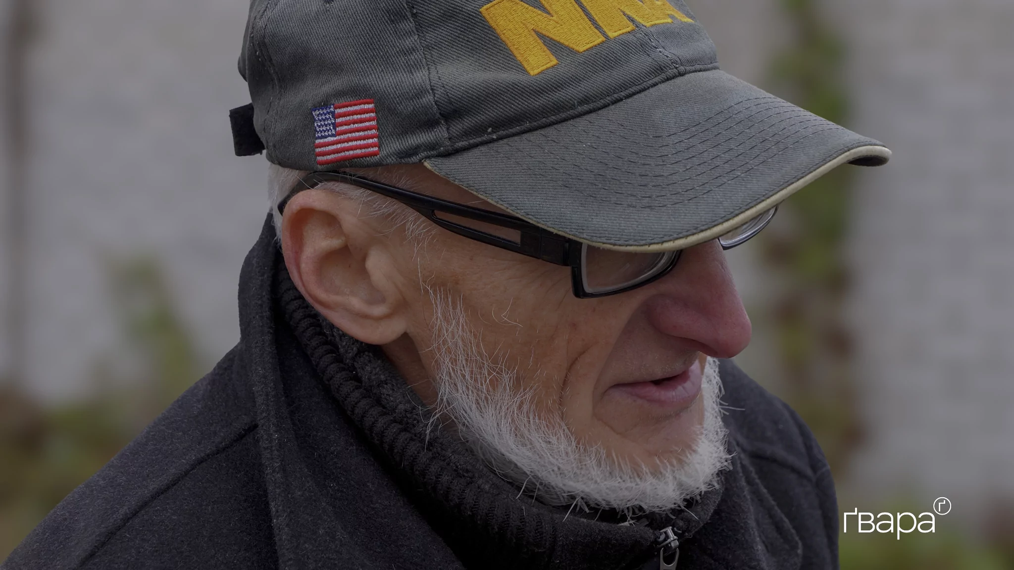 Чоловік з сідою бородою у кепці з американським прапором