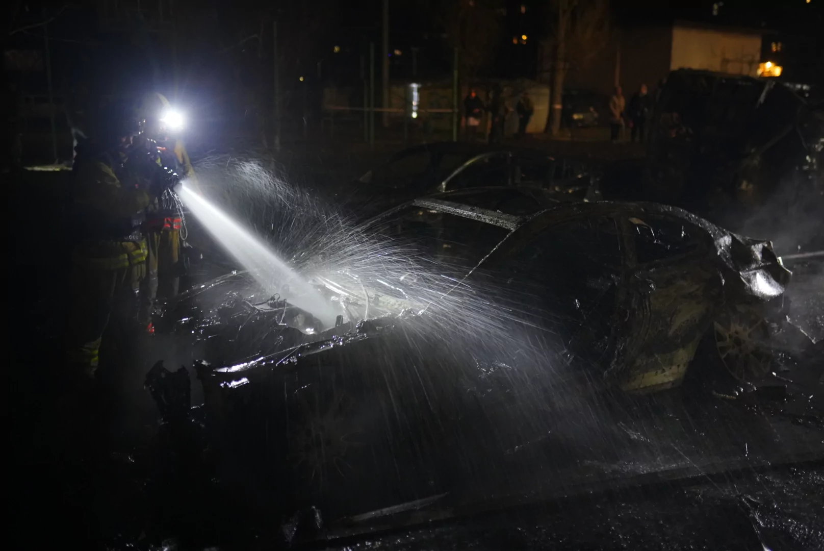 Firefighters extinguish a car that caught fire after Russian attack on Kharkiv