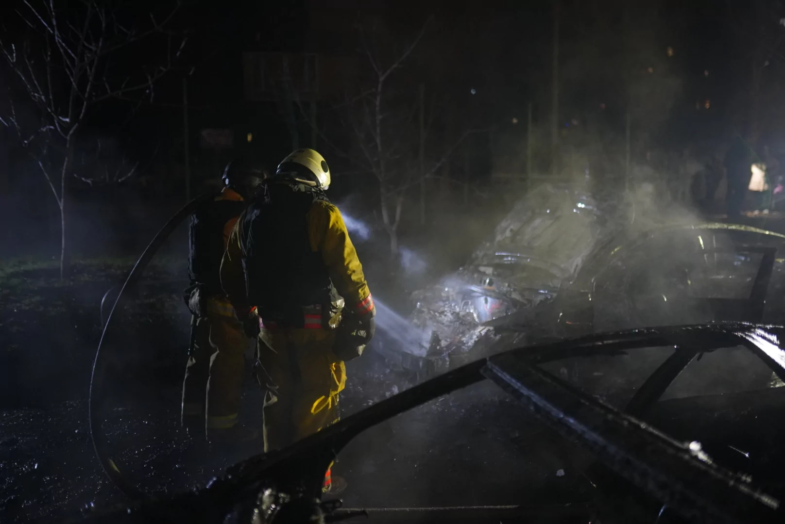 Firefighters extinguish a car that caught fire after Russian attack on Kharkiv