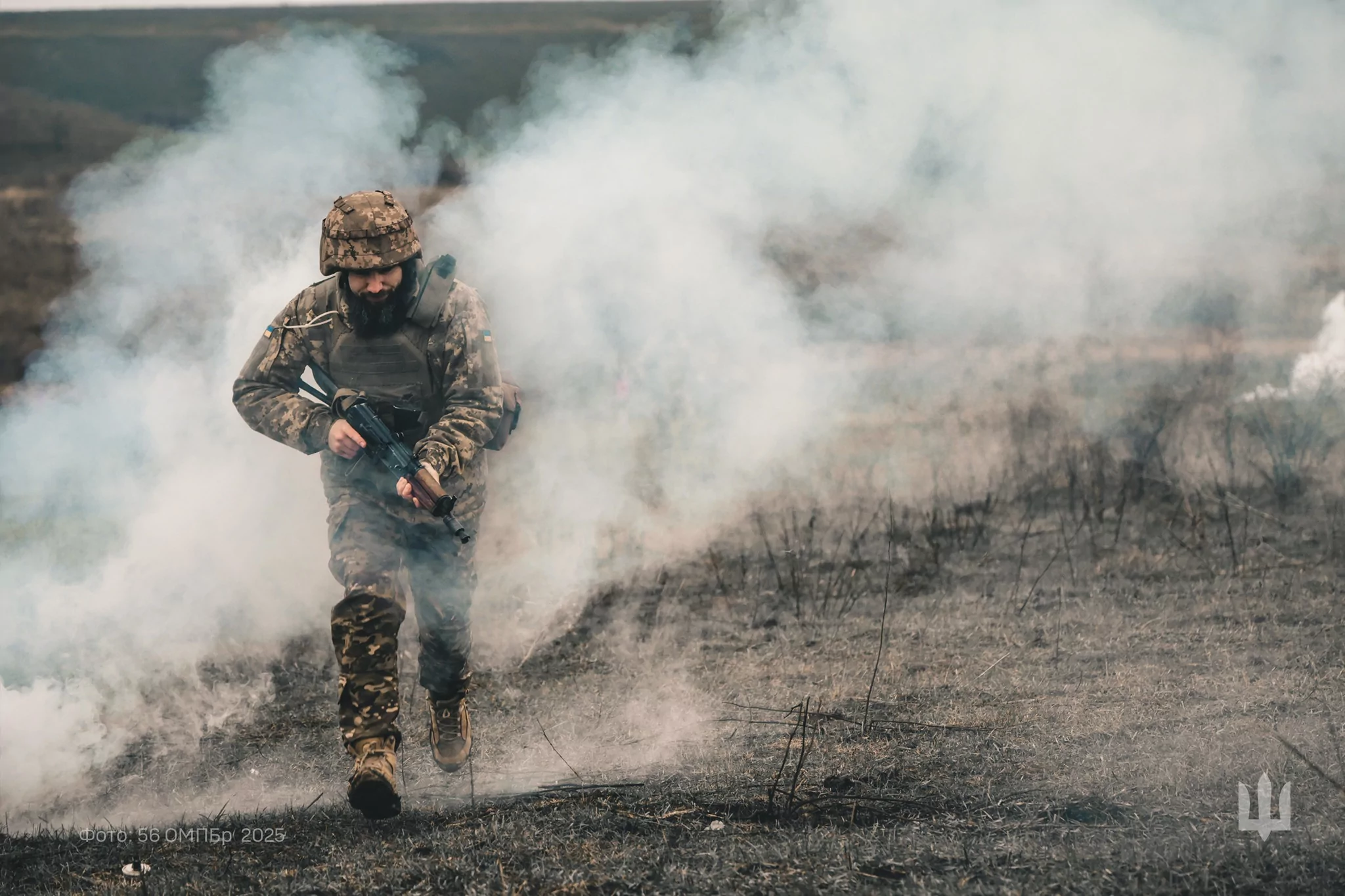 Ukrainian soldier in uniform running across a field
