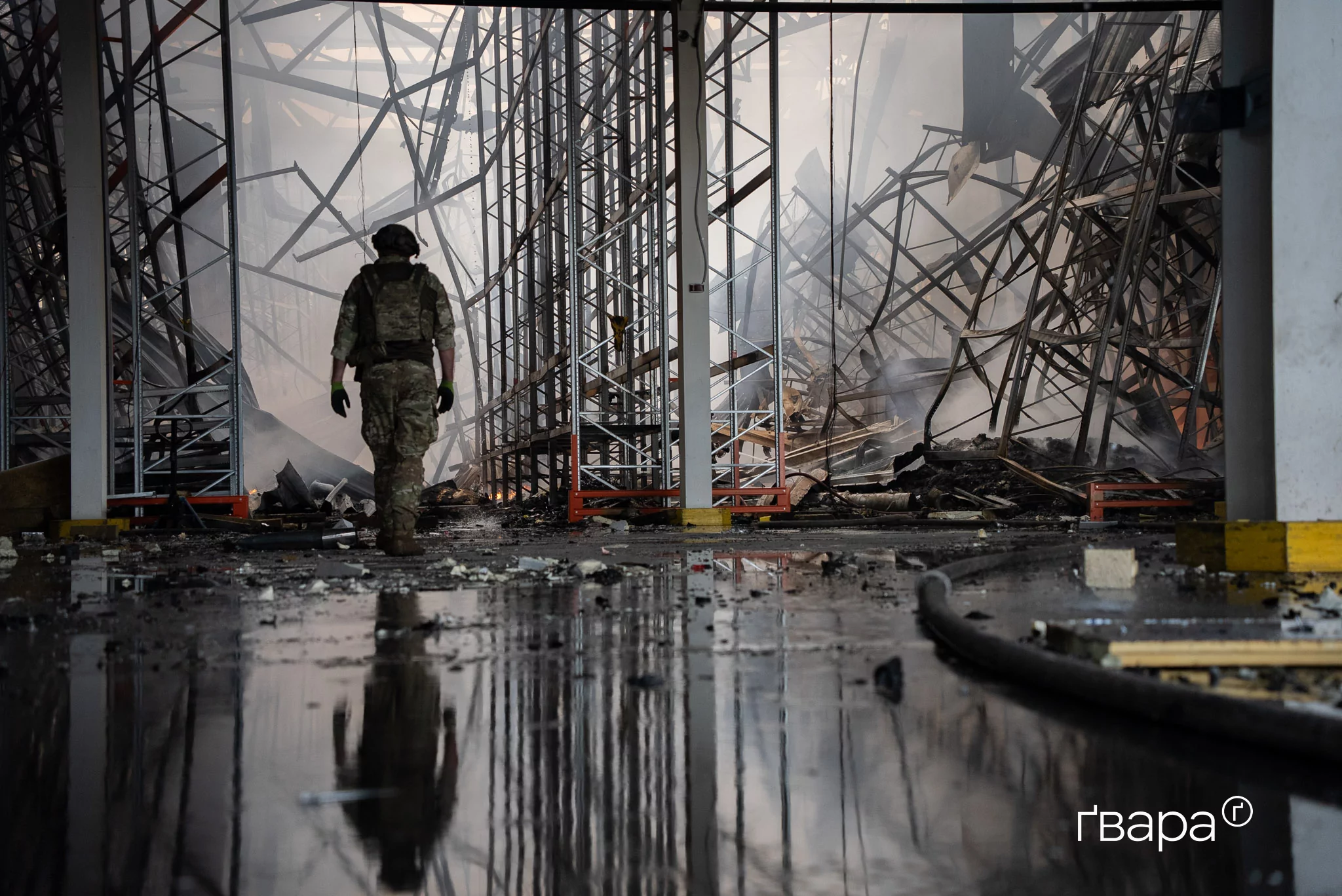 Піротехнік обстежує логістичний склад у Васищевому на Харківщині після російського удару. Пожежа охопила 20 000 м&sup2;. Загинув один робітник, четверо &mdash; отримали поранення. Липень 2025 року