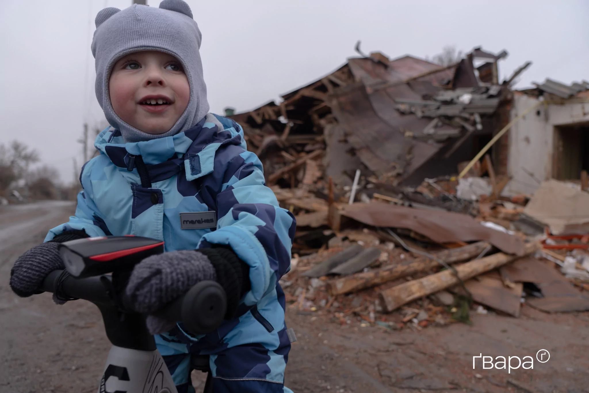 Дитина грається на тлі зруйнованого житлового будинку в Золочеві, знищеного прямим влучанням російської авіабомби. Січень 2025 року