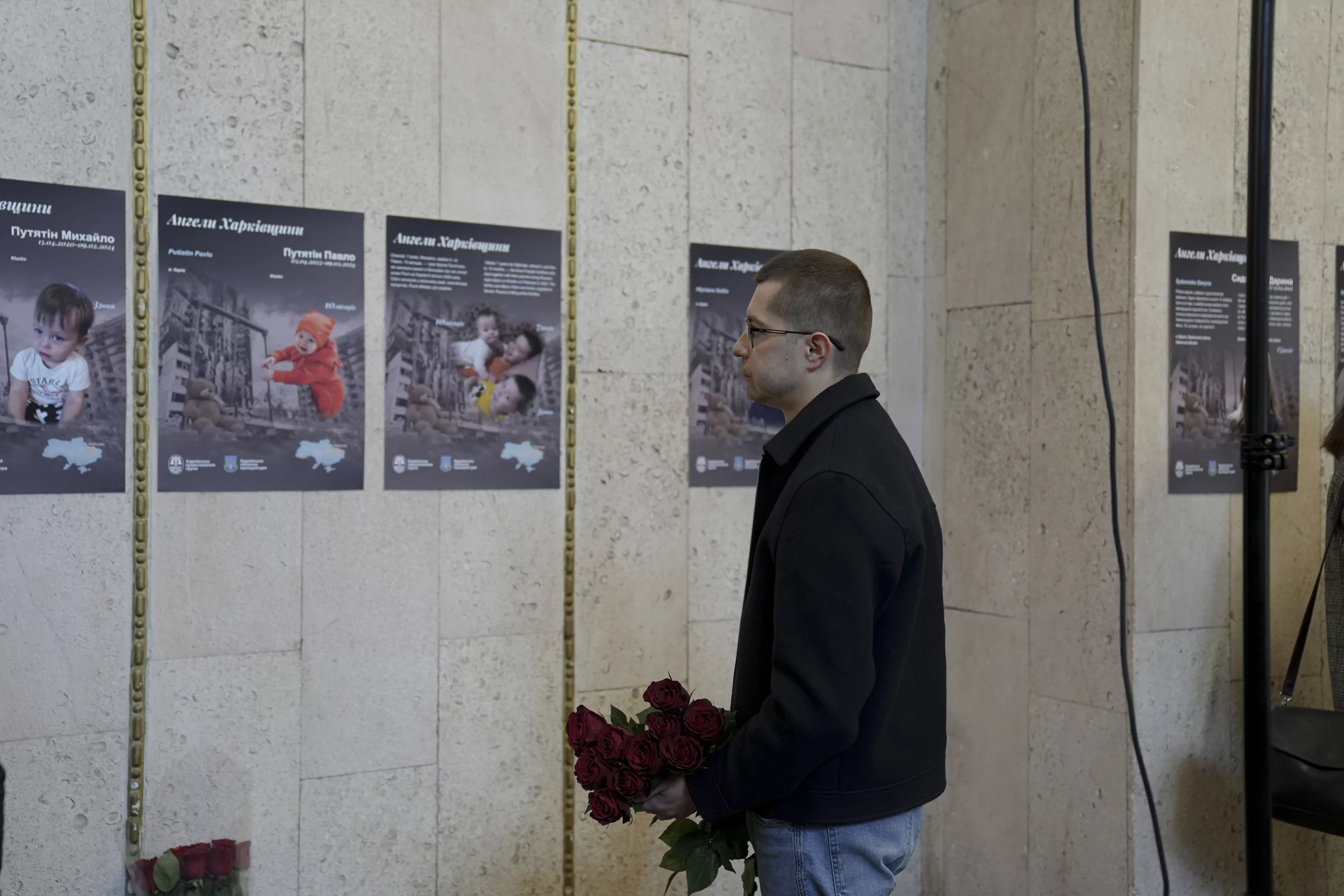 Man with flowers at opening of “Angels of Kharkiv region” photo exhibition in Kharkiv