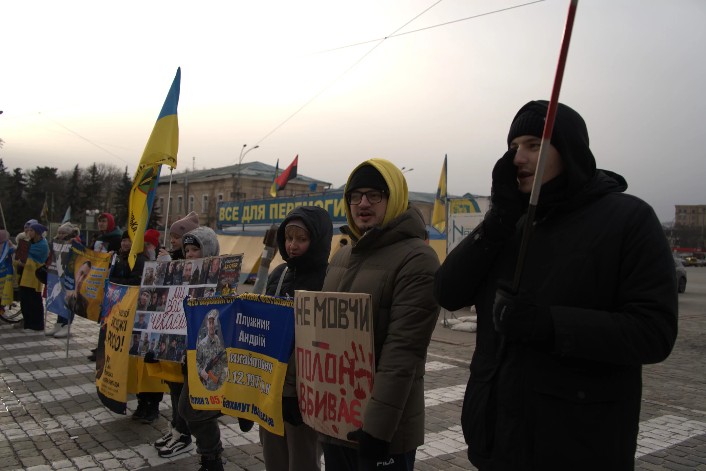 A row of people with signs standing on the Freedom Square of Kharkiv