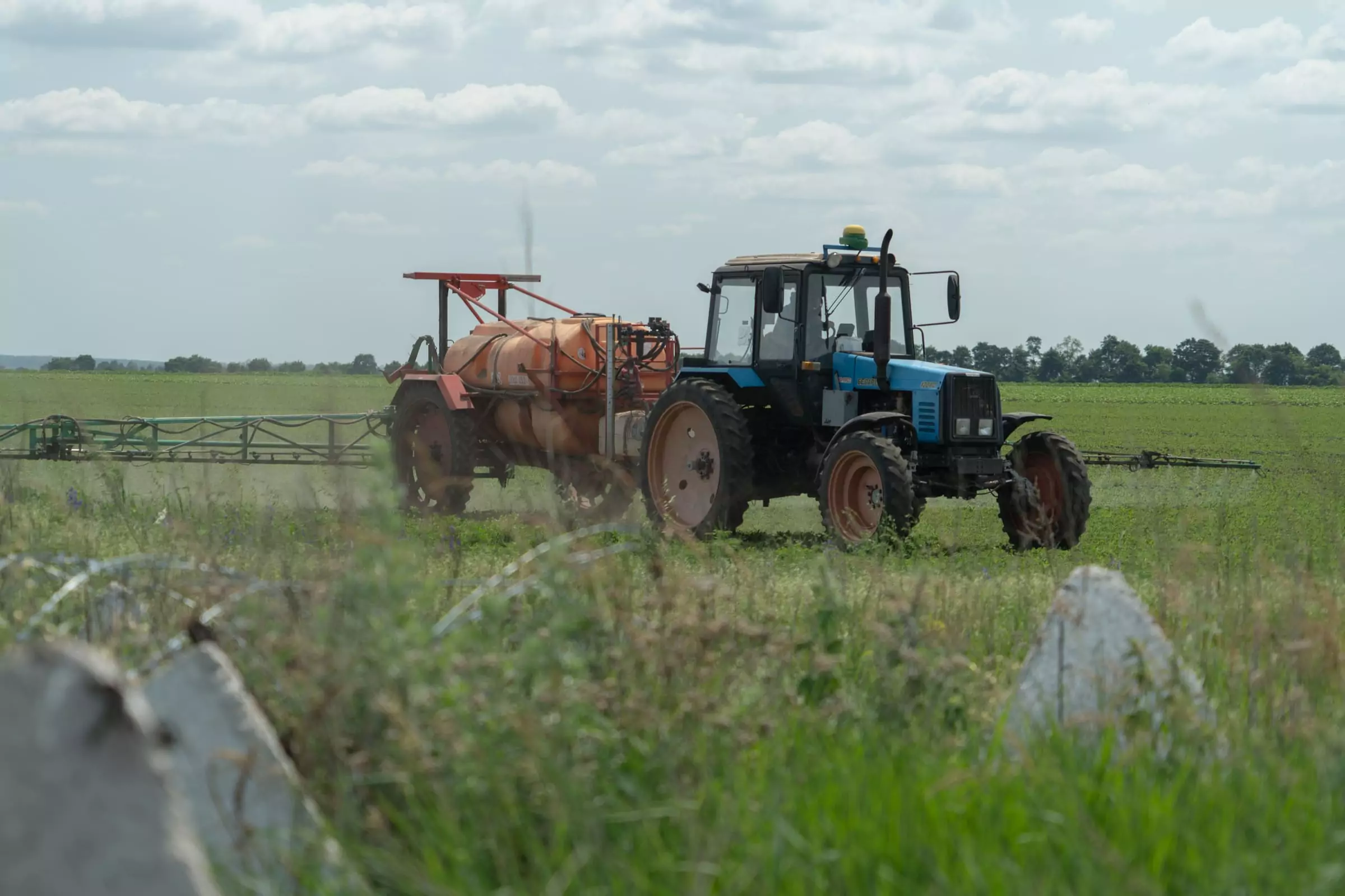 A tractor is fertilizing the field two kilometers away from the Russian border. June 2025