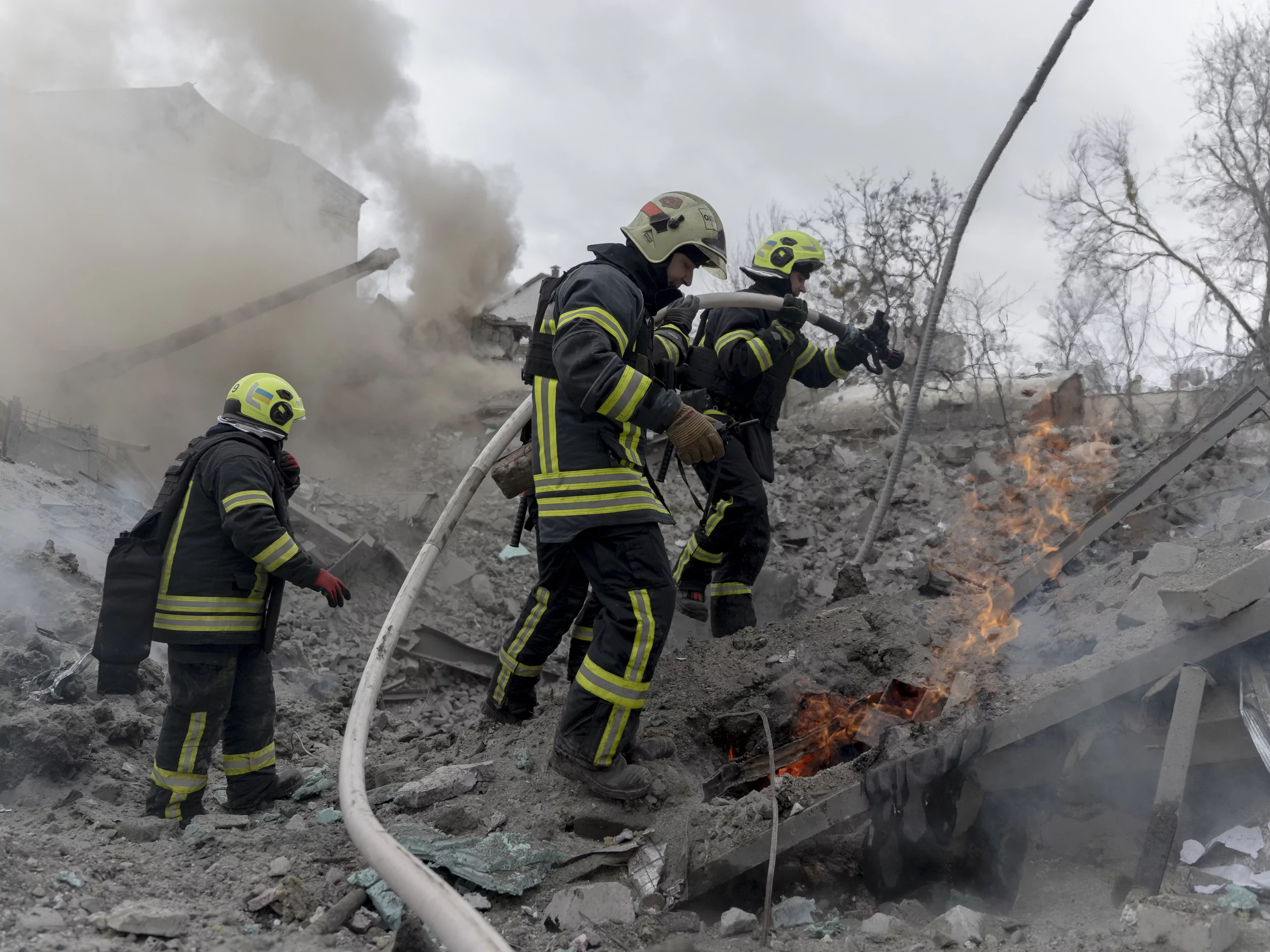 Firefighters extinguish a fire in a building destroyed by a Russian missile in Kharkiv