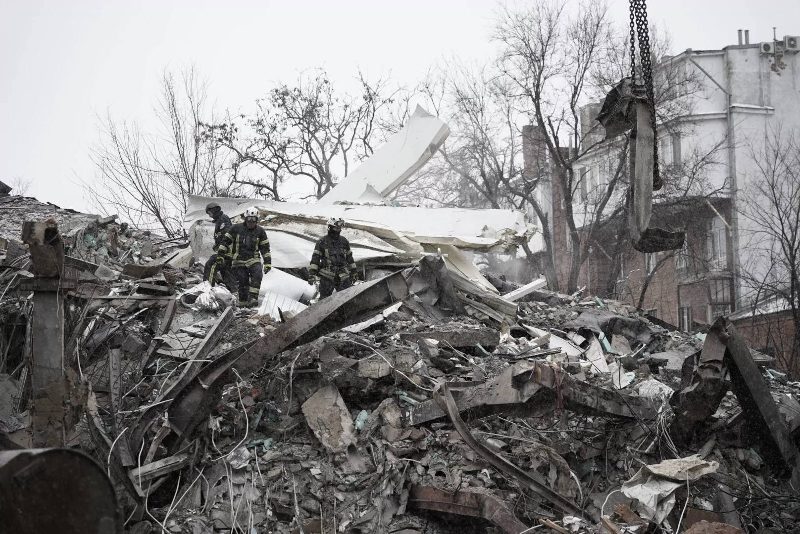Rescuers clear debris from a destroyed apartment building after a Russian attack on Kharkiv
