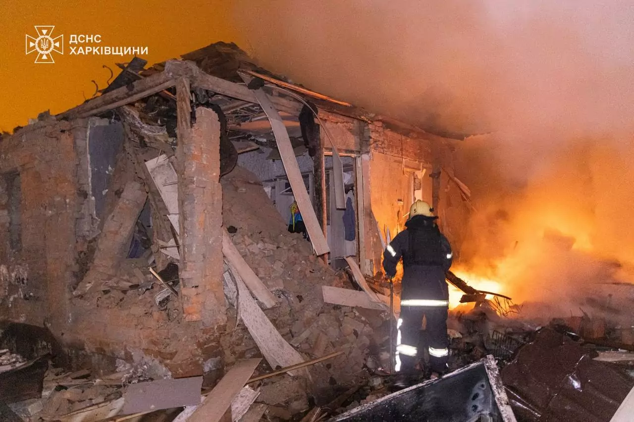 A rescuer putting out the fire that overtook a house in Kharkiv
