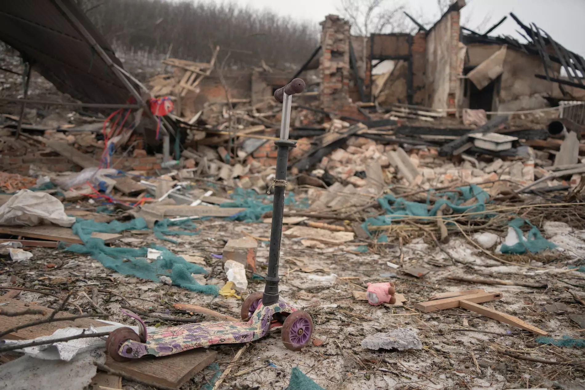 A pink scooter standing amidst the rubble of the burnt house.