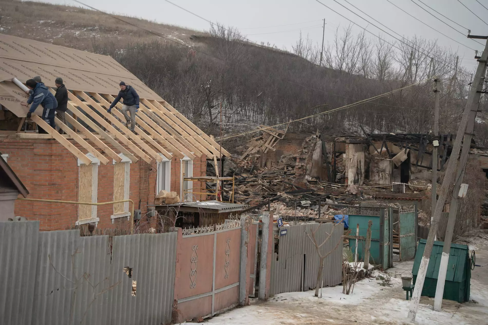 The house is being repaired (on the left), the burnt rubble of another house hit with Russian drone attack (right)
