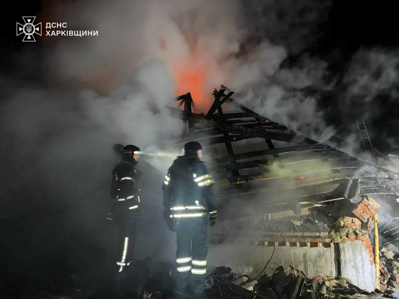 Firefighters extinguish a house on fire after it was hit by a Russian drone in Bohodukhiv