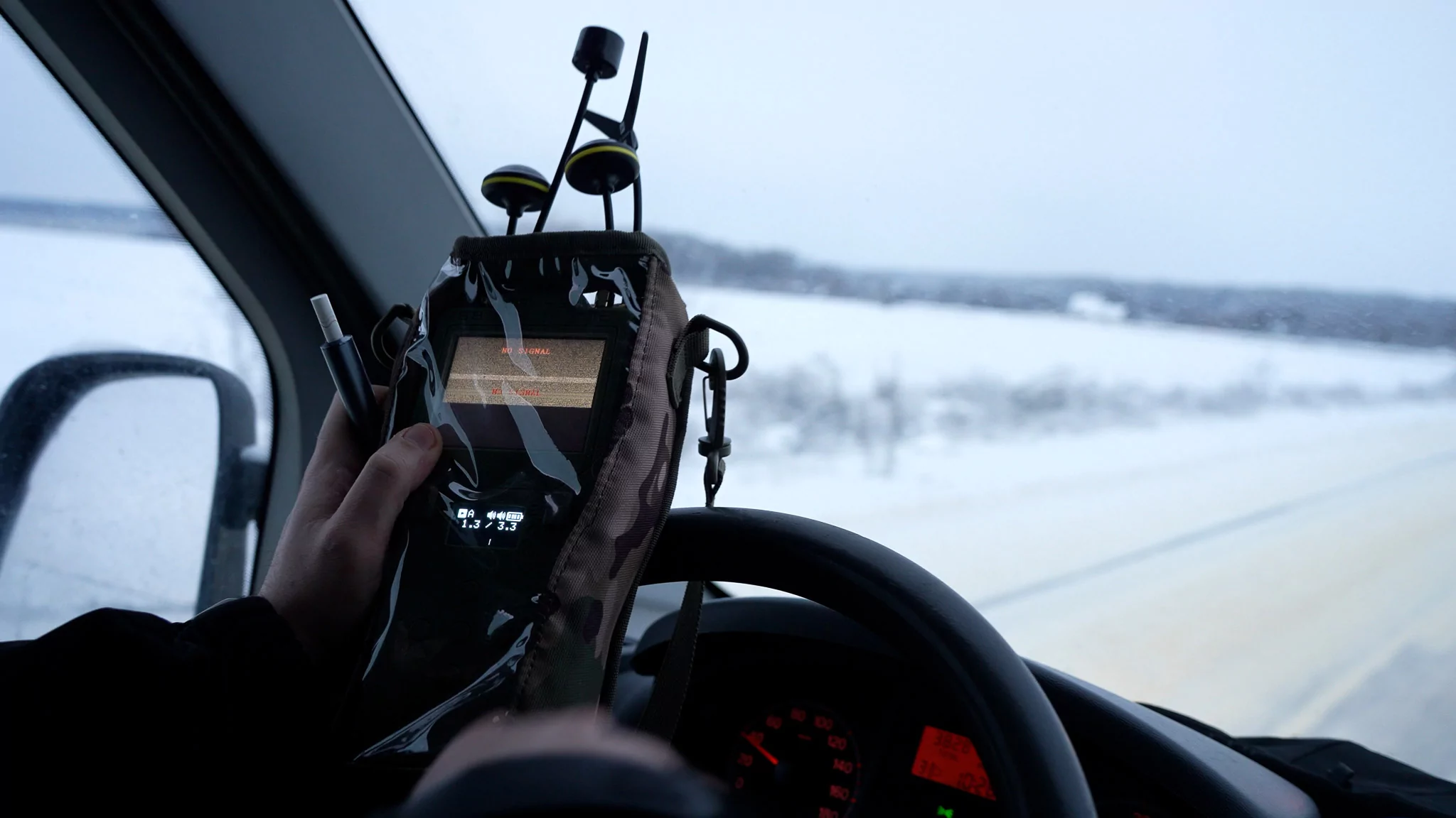 A volunteer holds a drone detector while driving through the Chuhuiv district