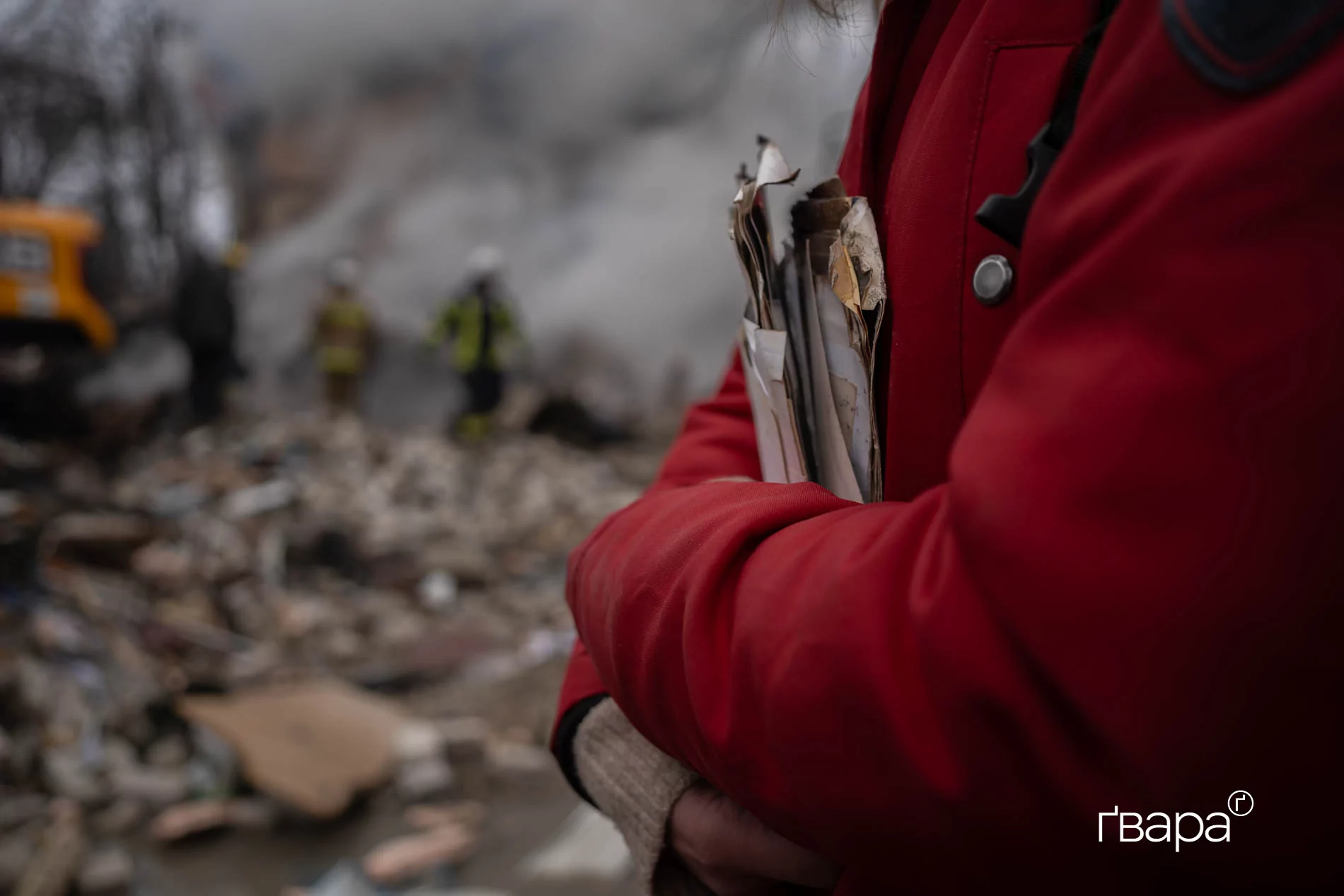 Анна, жителька однієї з квартир у під'зді, зруйнованим російським обстрілом 7 березня. У неї в руках &mdash; сімейні фотографії, що порозліталися після обстрілу з її дому. / Фото: Ґвара Медіа, Яна Слємзіна