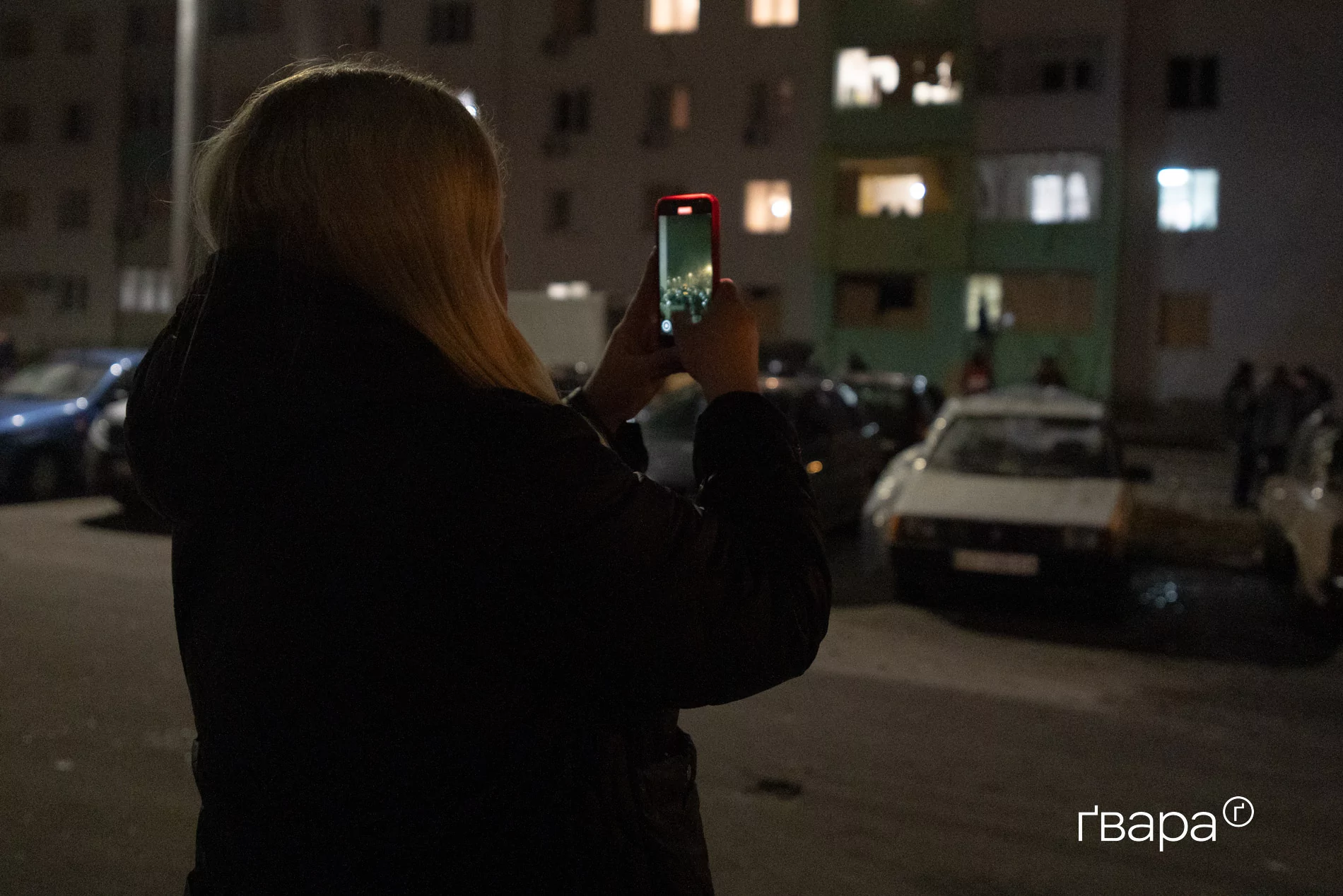 дівчина на фоні пошкодженого будинку