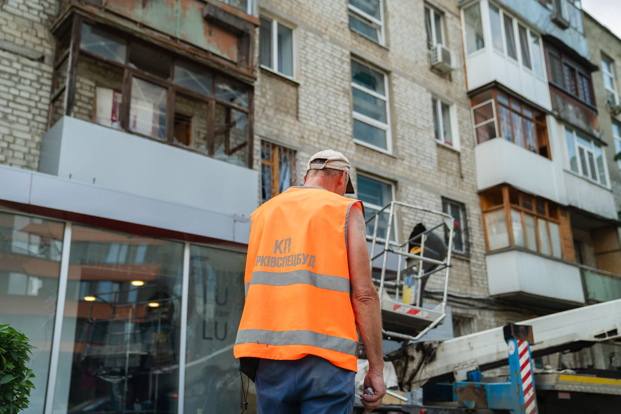 A utility worker near a damaged building in Kharkiv