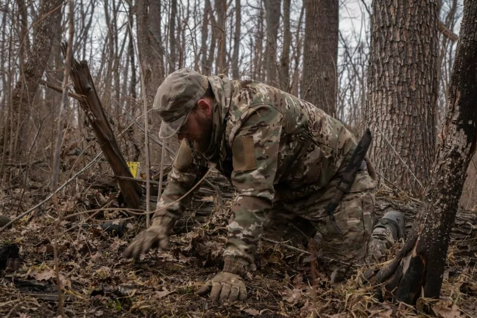 Oleksii is raking the leaves with his hands