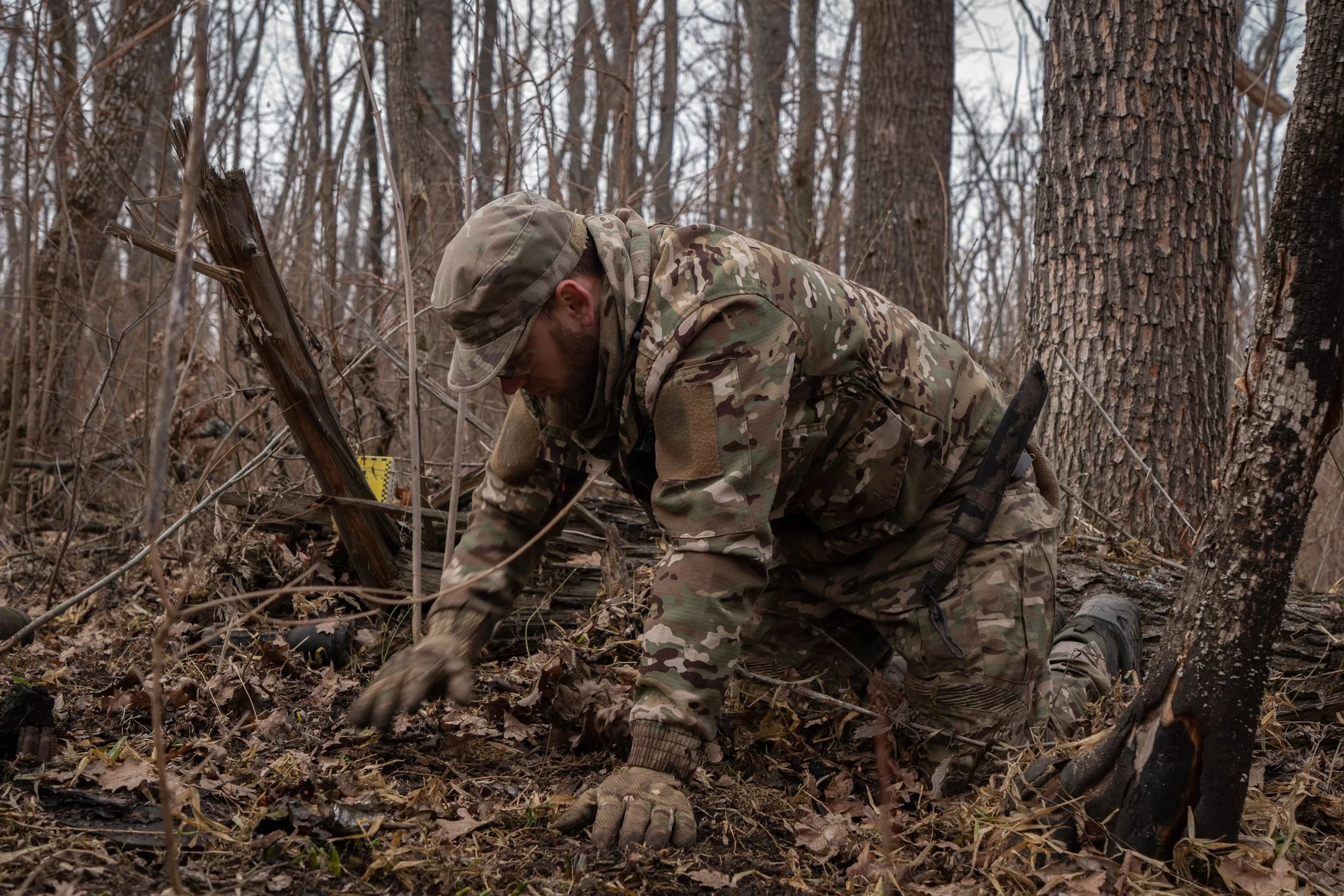 Oleksii is raking the leaves with his hands